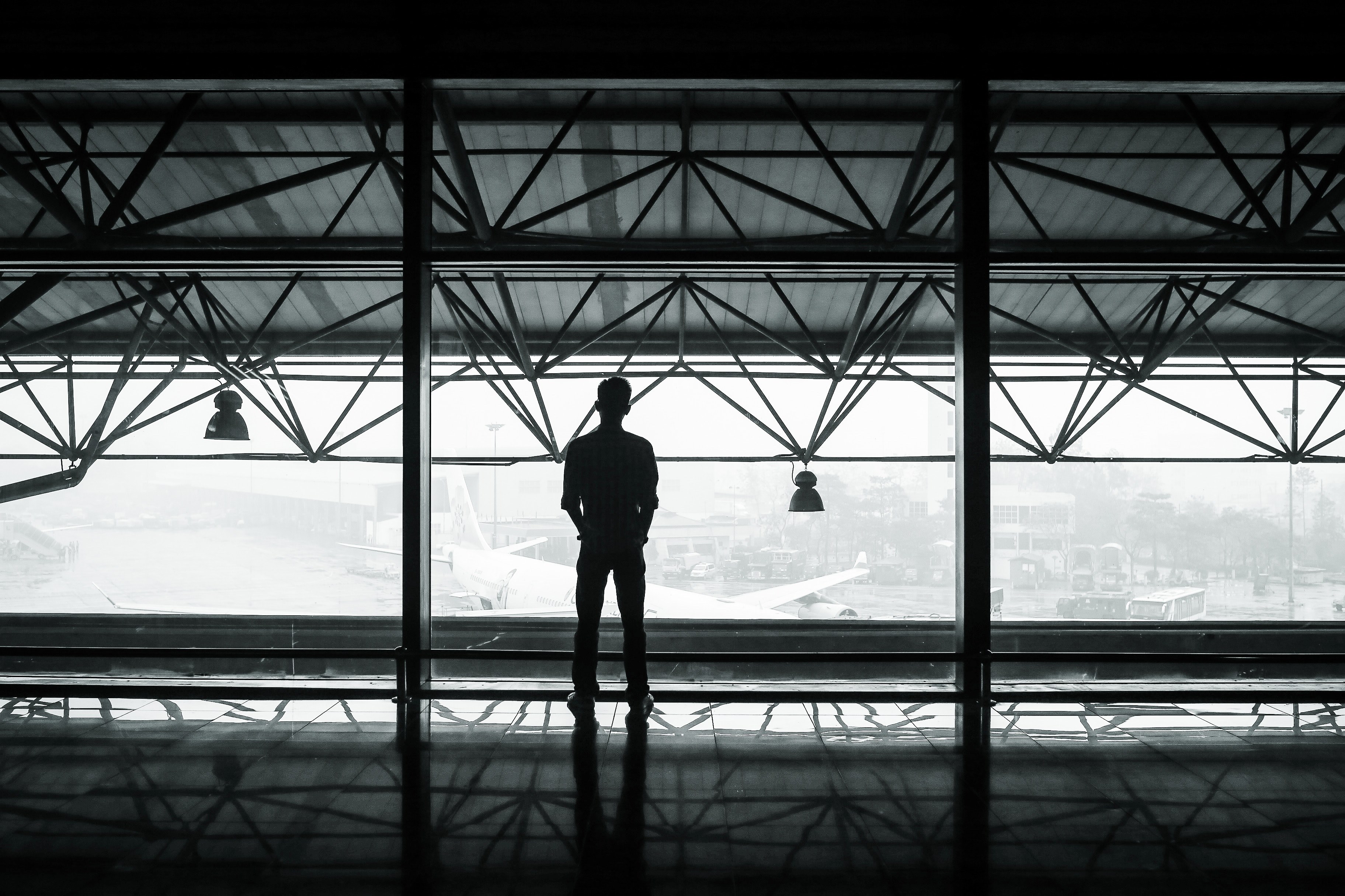 a silhouetted man looks at a plane out an airport window, man looks out airport window 4k, HD Wallpaper
