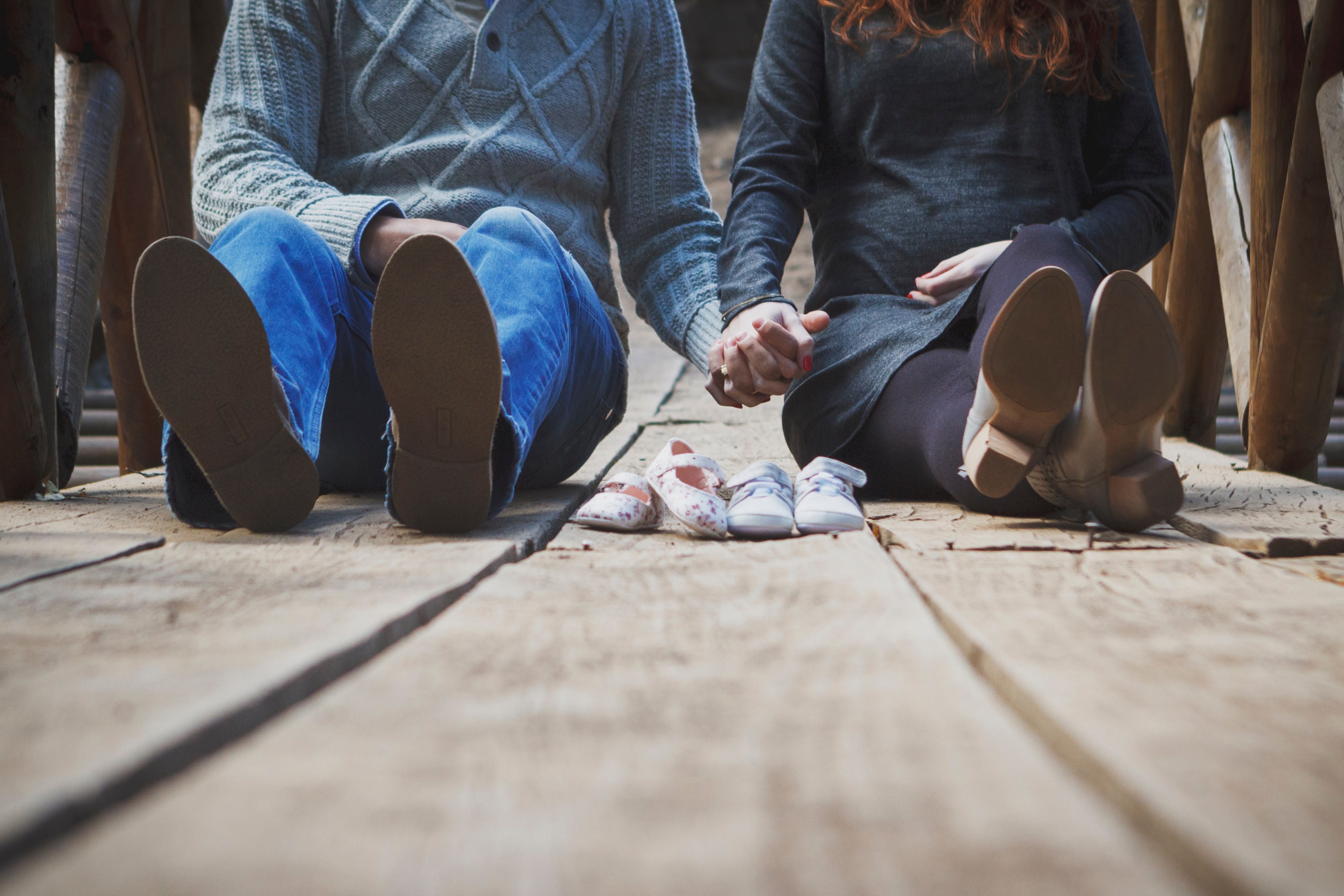 couple seated on wooden walkway holding hands over childrens shoes, waitimg for the twins 4k, HD Wallpaper