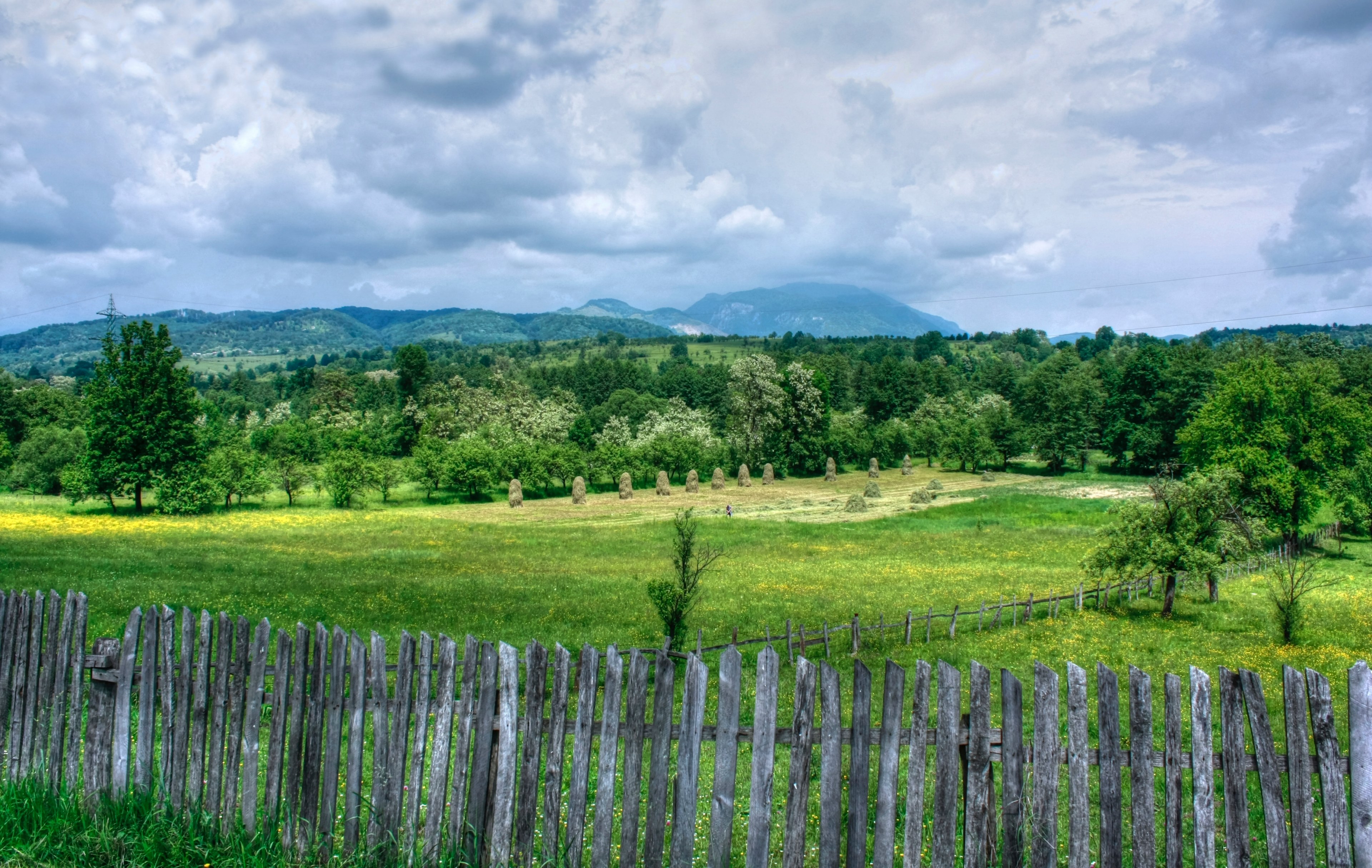 a wooden fence enclosing a meadow with heaps of hay in soveja, rustic fence by a meadow 4k, HD Wallpaper