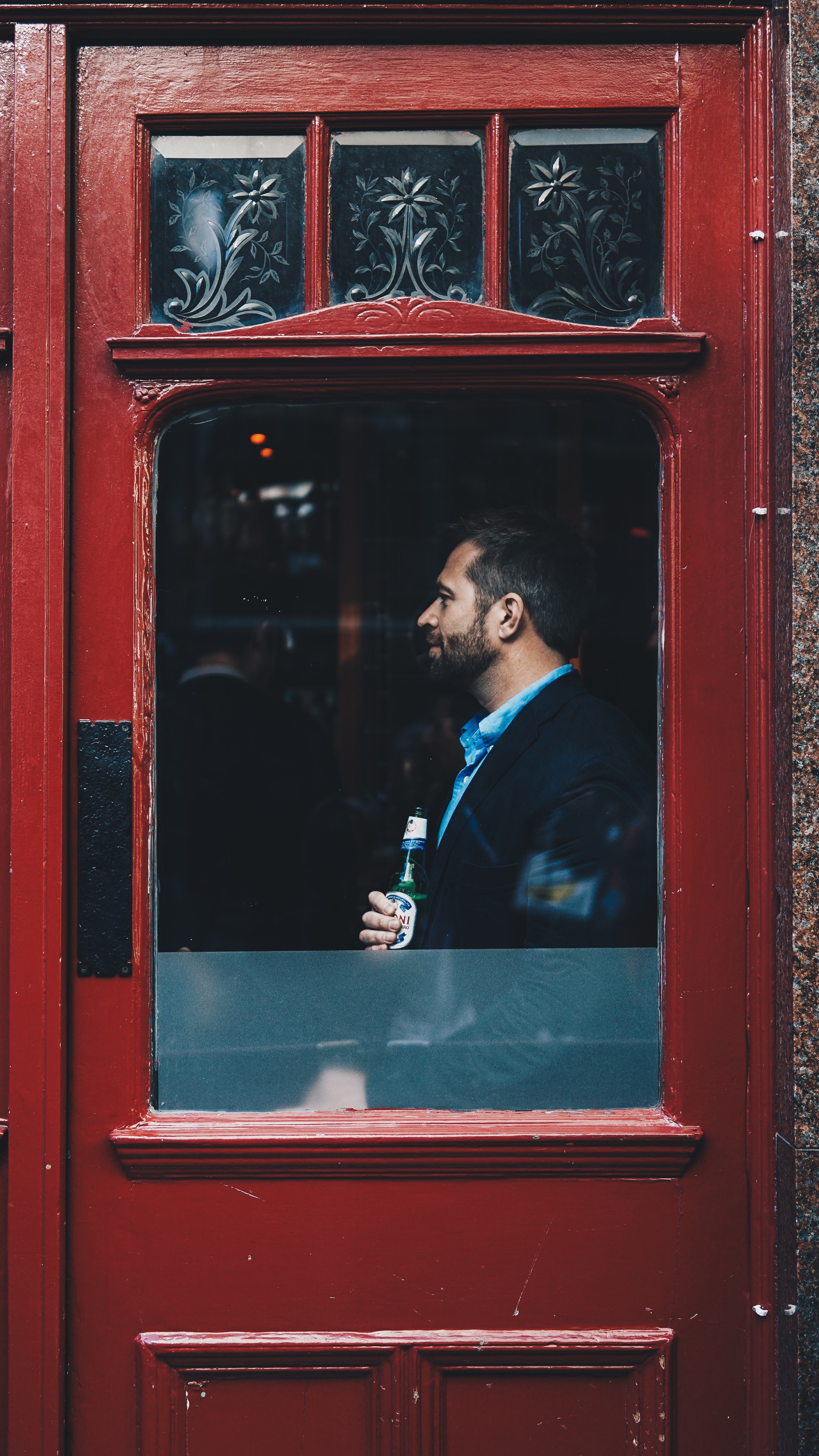 a man holding a beer and standing at the window of a red door in china town, beer brings happiness 4k, Phone HD Wallpaper
