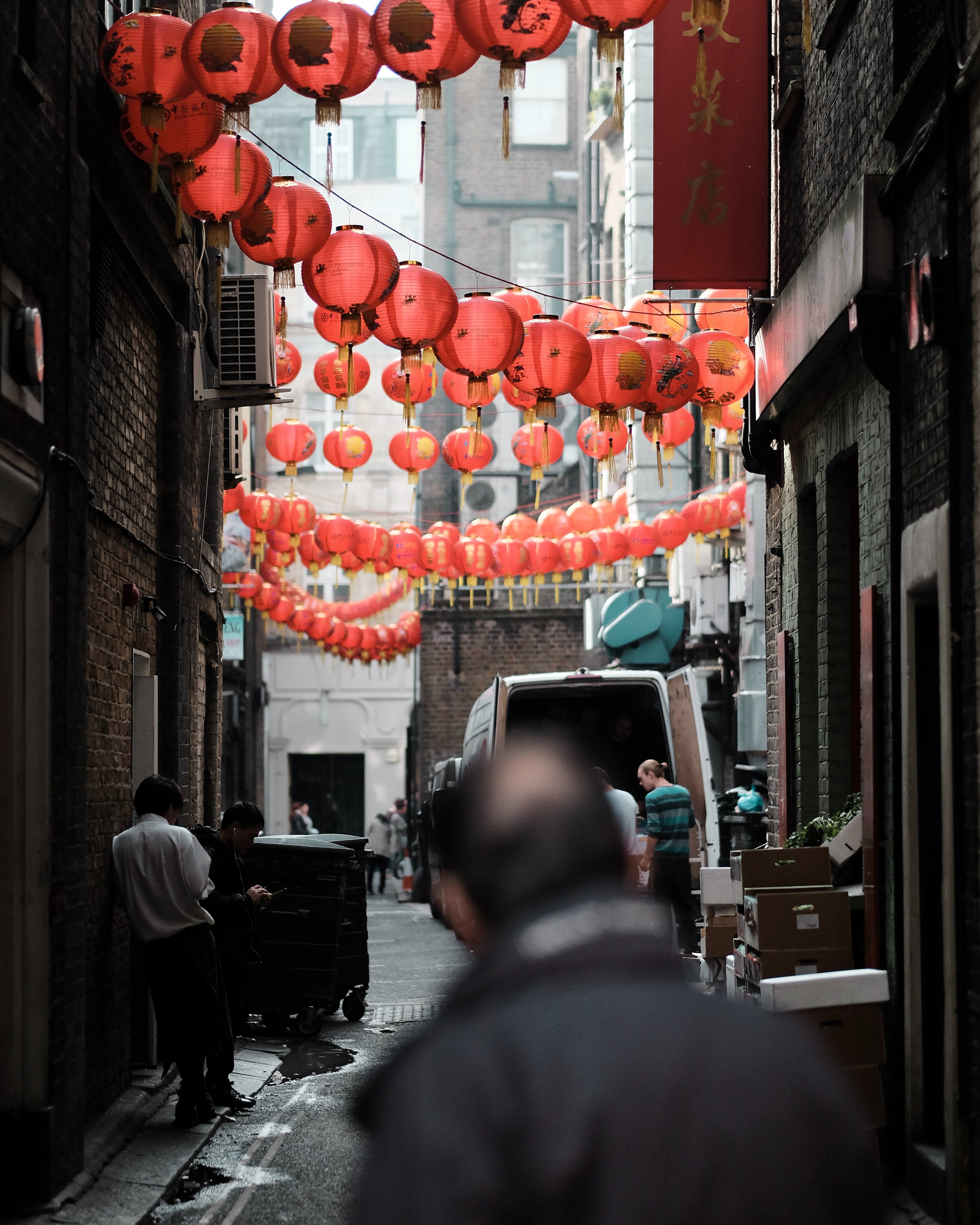 a man looks down an alleyway with strings of paper lanterns hung from the buildings, chinatown 4k, Phone HD Wallpaper