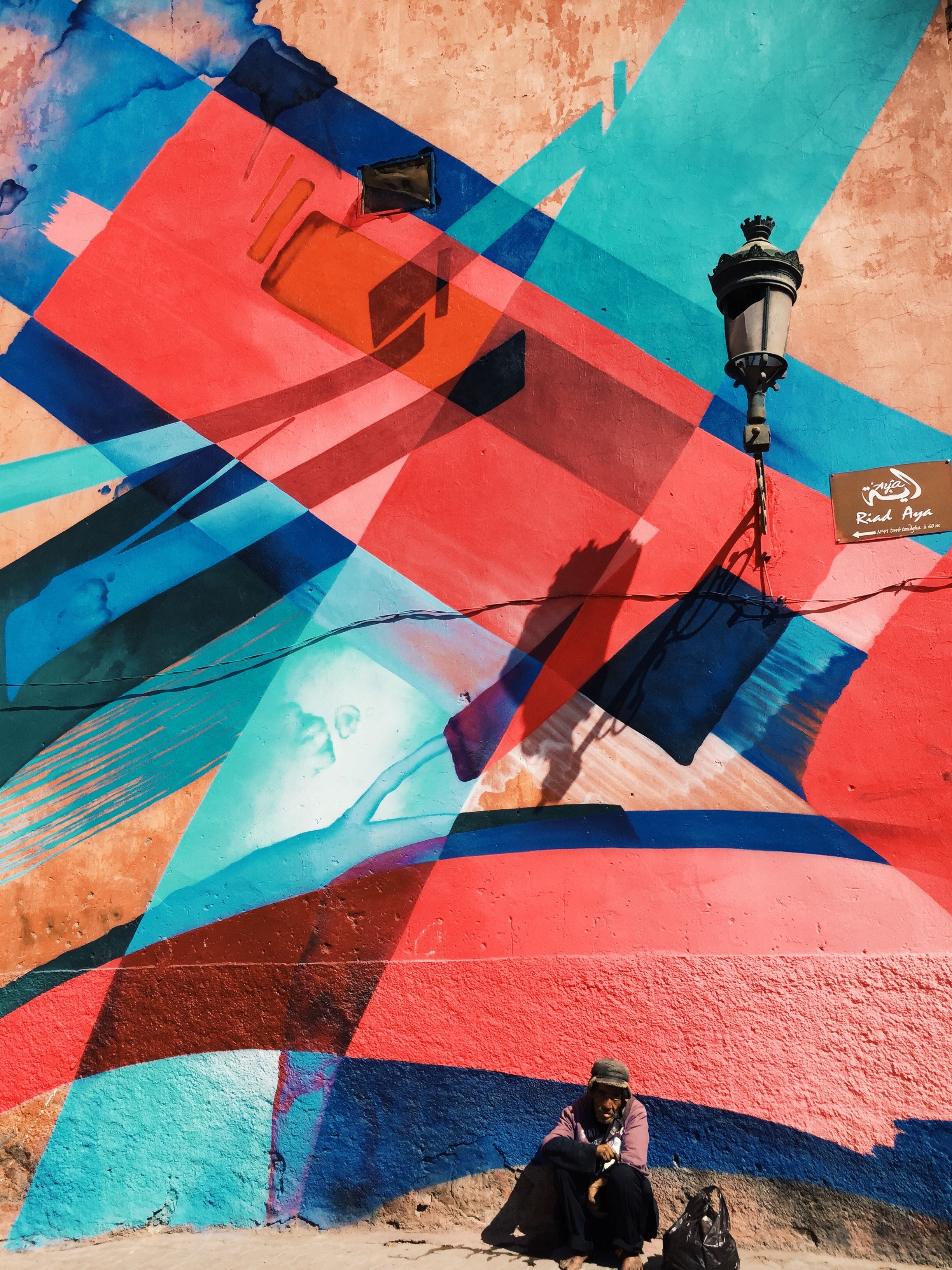 main sitting near colorful graffiti on wall and street lamp bab doukkala marrakesh marrakesh tensift el haouz morocco, man in front of abstract mural 4k, Phone HD Wallpaper