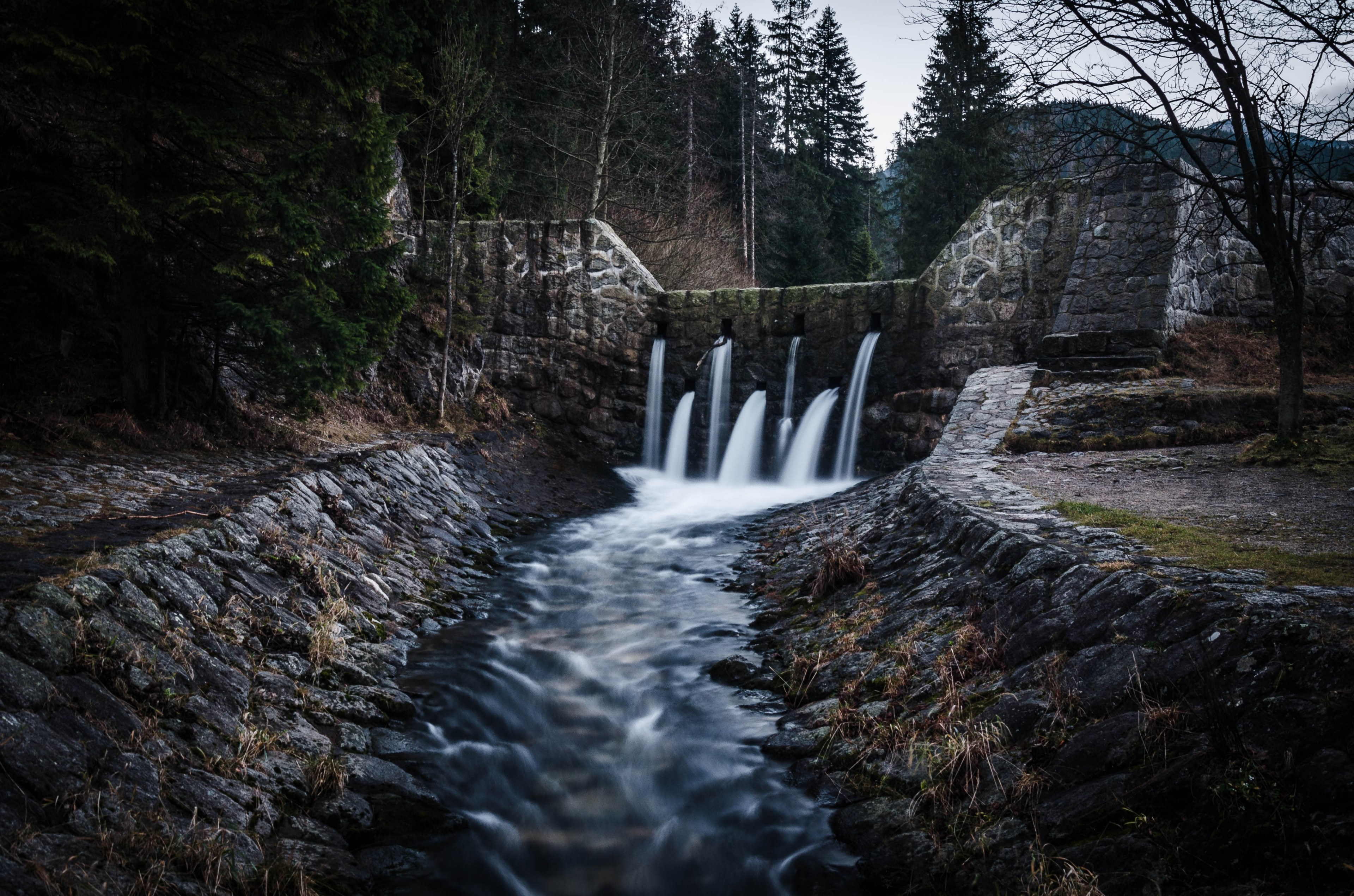 a stream flowing through several openings in a stone bridge, water flowing through a bridge 4k, HD Wallpaper