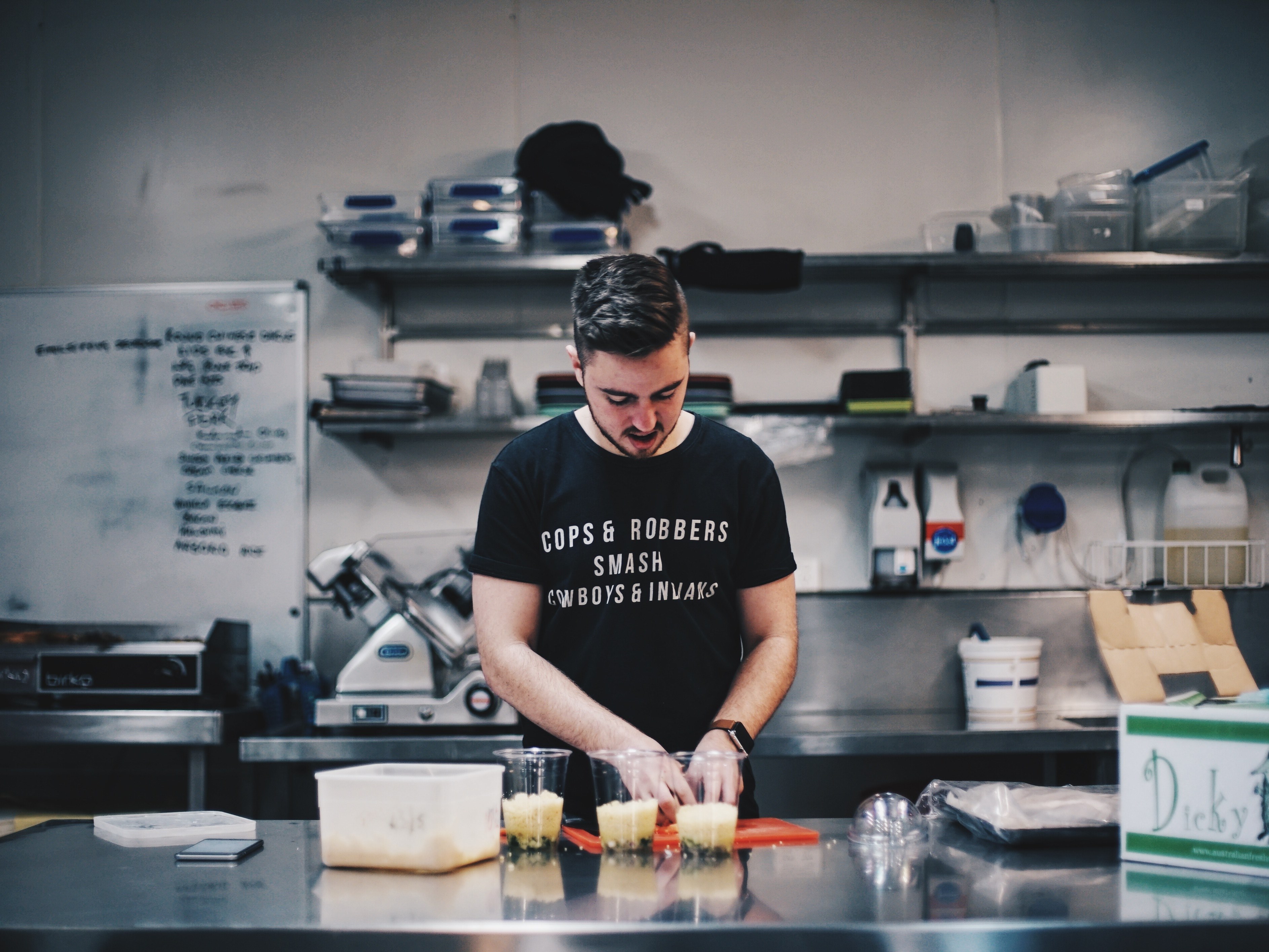 a man in a black t shirt preparing food in a restaurant, not confused_ 4k, HD Wallpaper