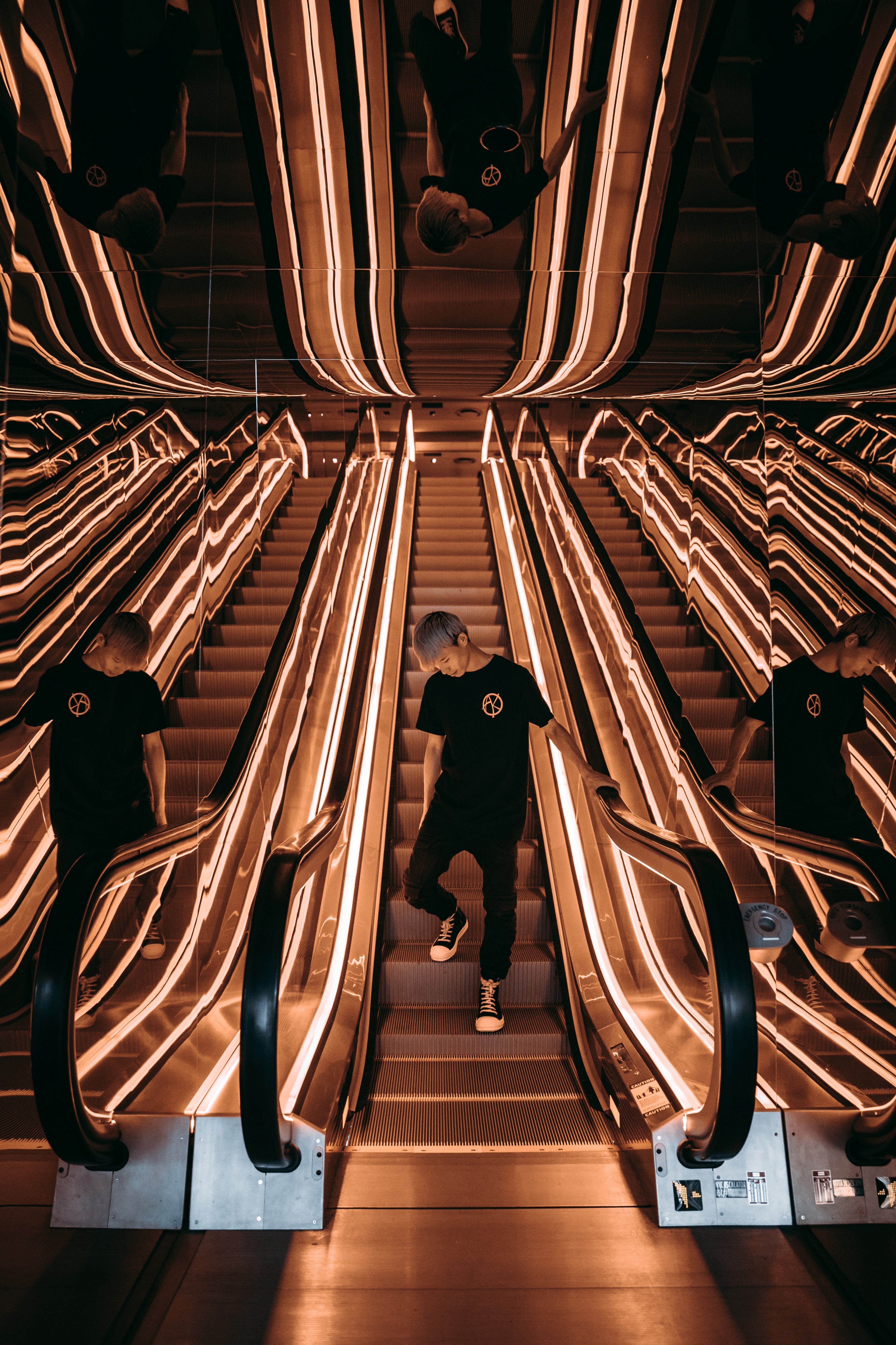 a man wearing all black reflects in two mirrors as he rides an escalator while looking down, _being single seeing double making triple 4k, Phone HD Wallpaper