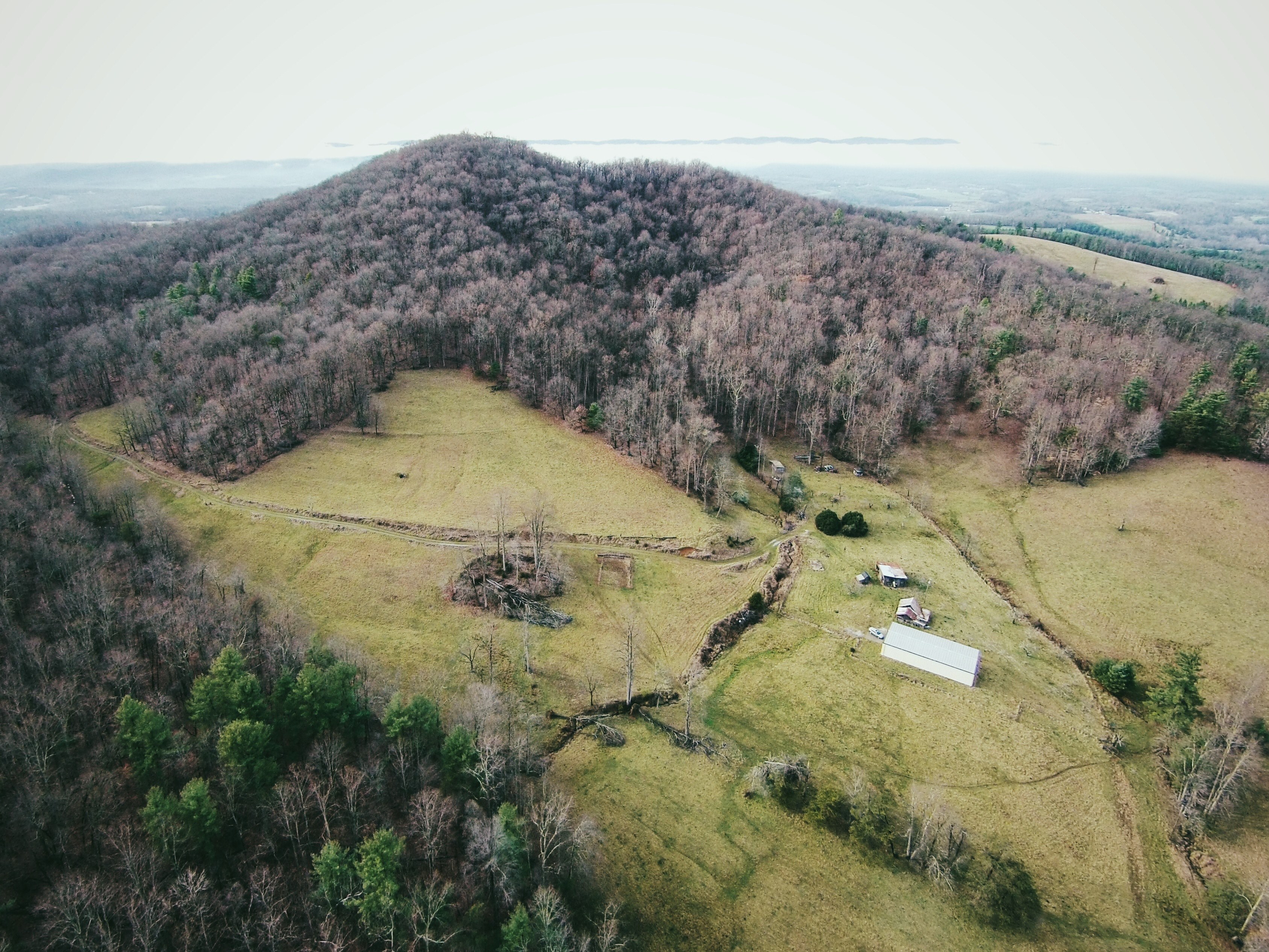 several small buildings in a green plain near a forest, shacks in a dry plain 4k, HD Wallpaper