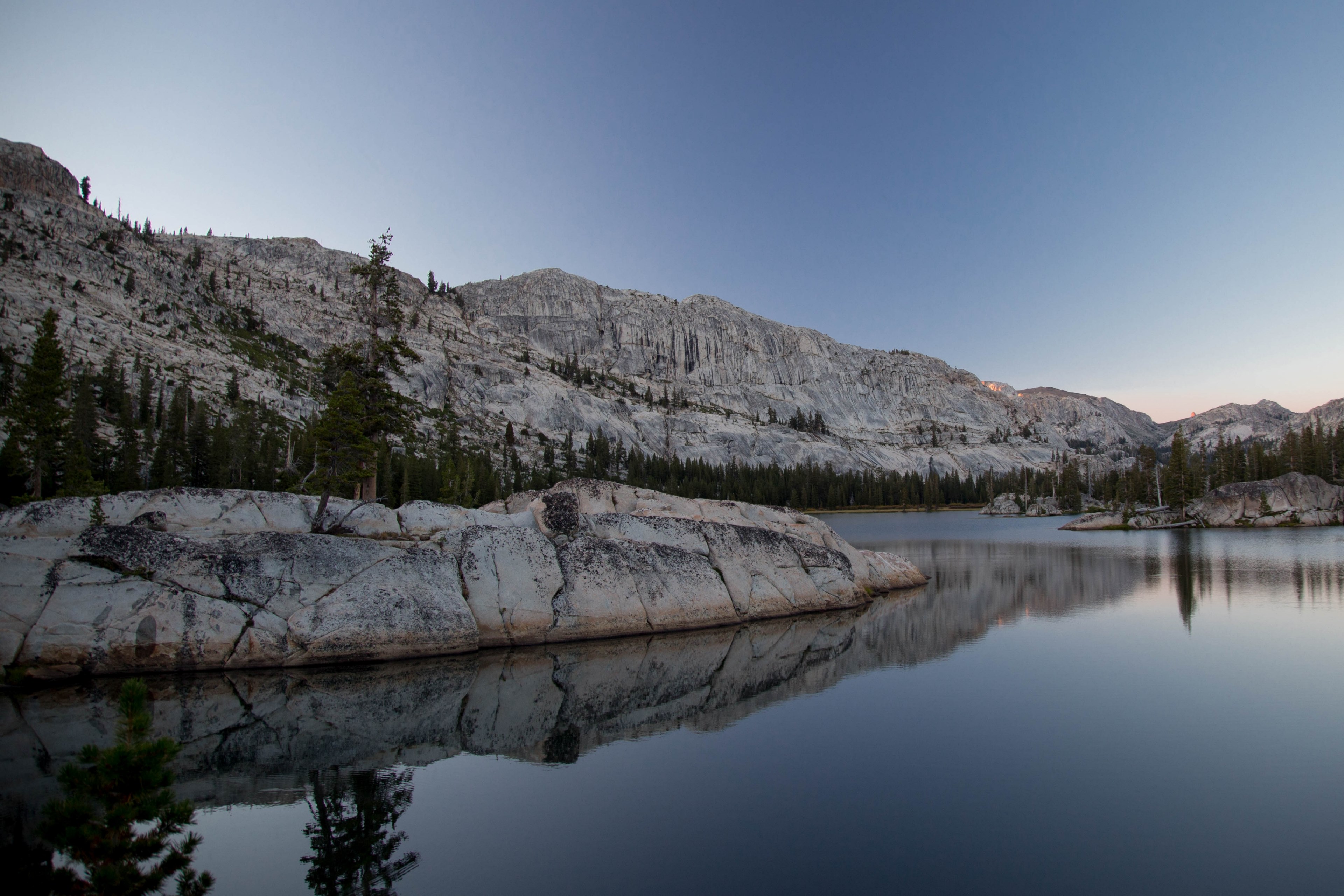 a lake during sunrise showing the reflection of rocks and trees surrounding it, still waters by the mountains 4k, HD Wallpaper
