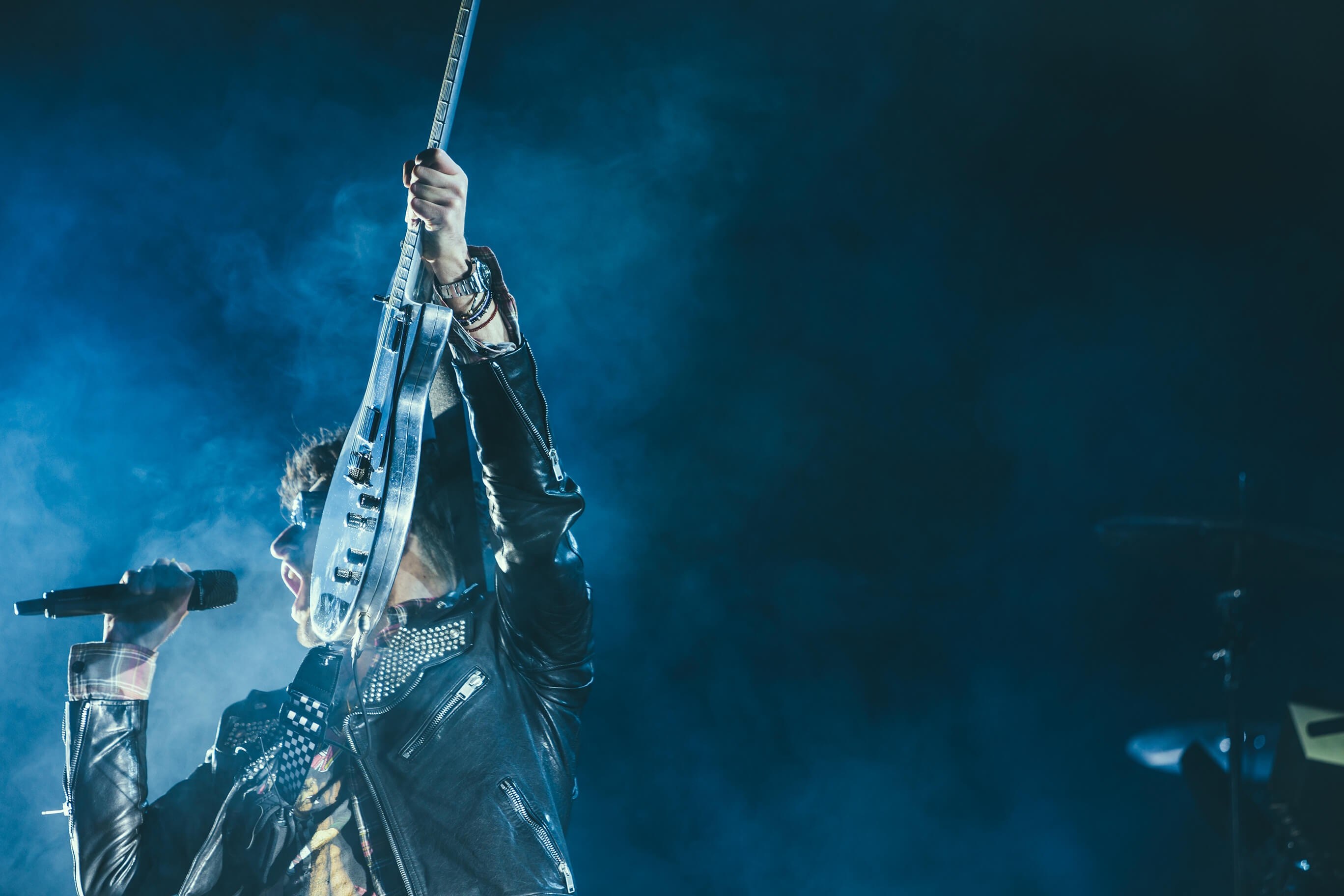 a man in a leather jacket holds up an electric guitar and shouts into the microphone, rockstar in the night_ 4k, HD Wallpaper