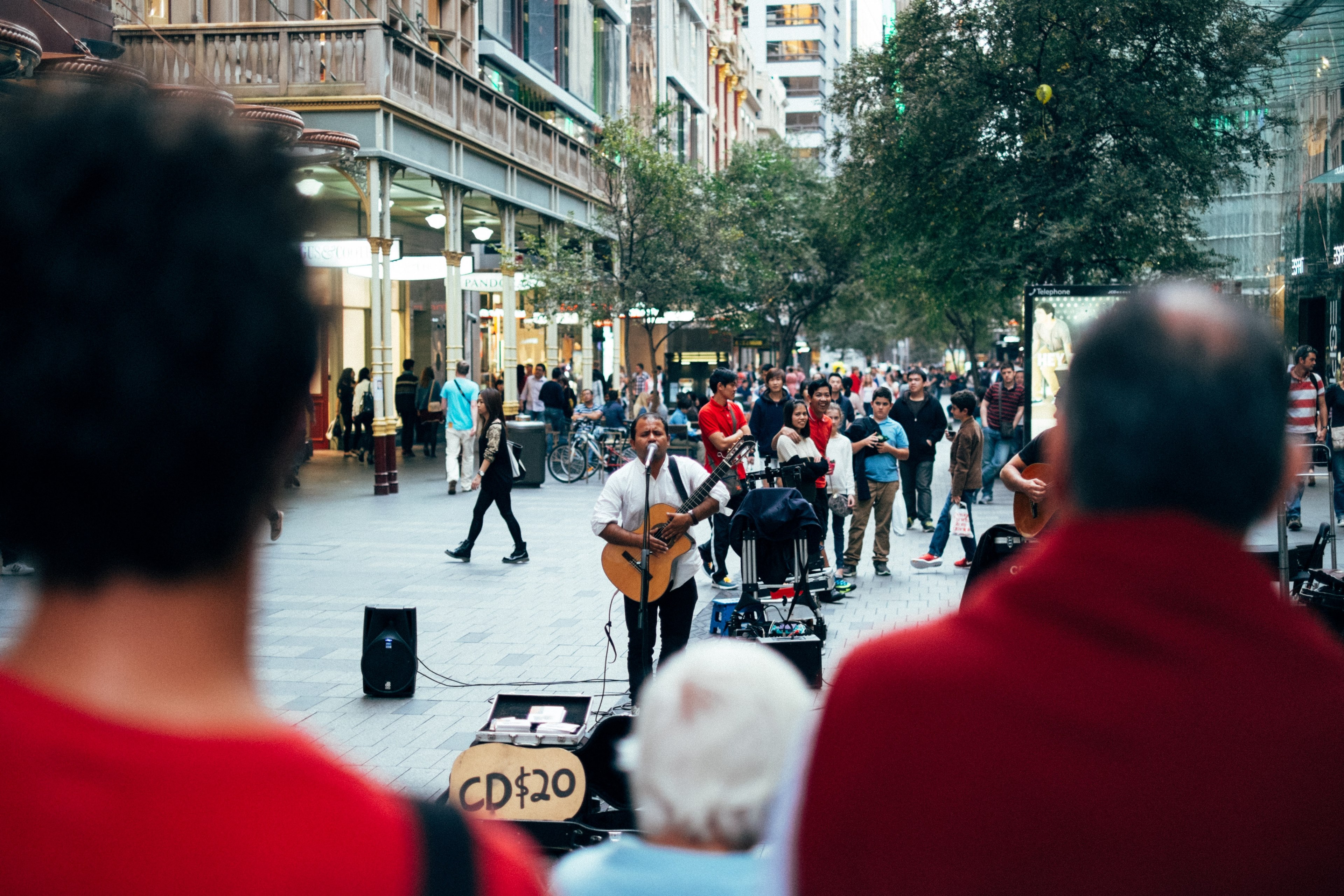 a male guitar player busking on a crowded street with a sign reading cd 20, male busker on a busy street 4k, HD Wallpaper