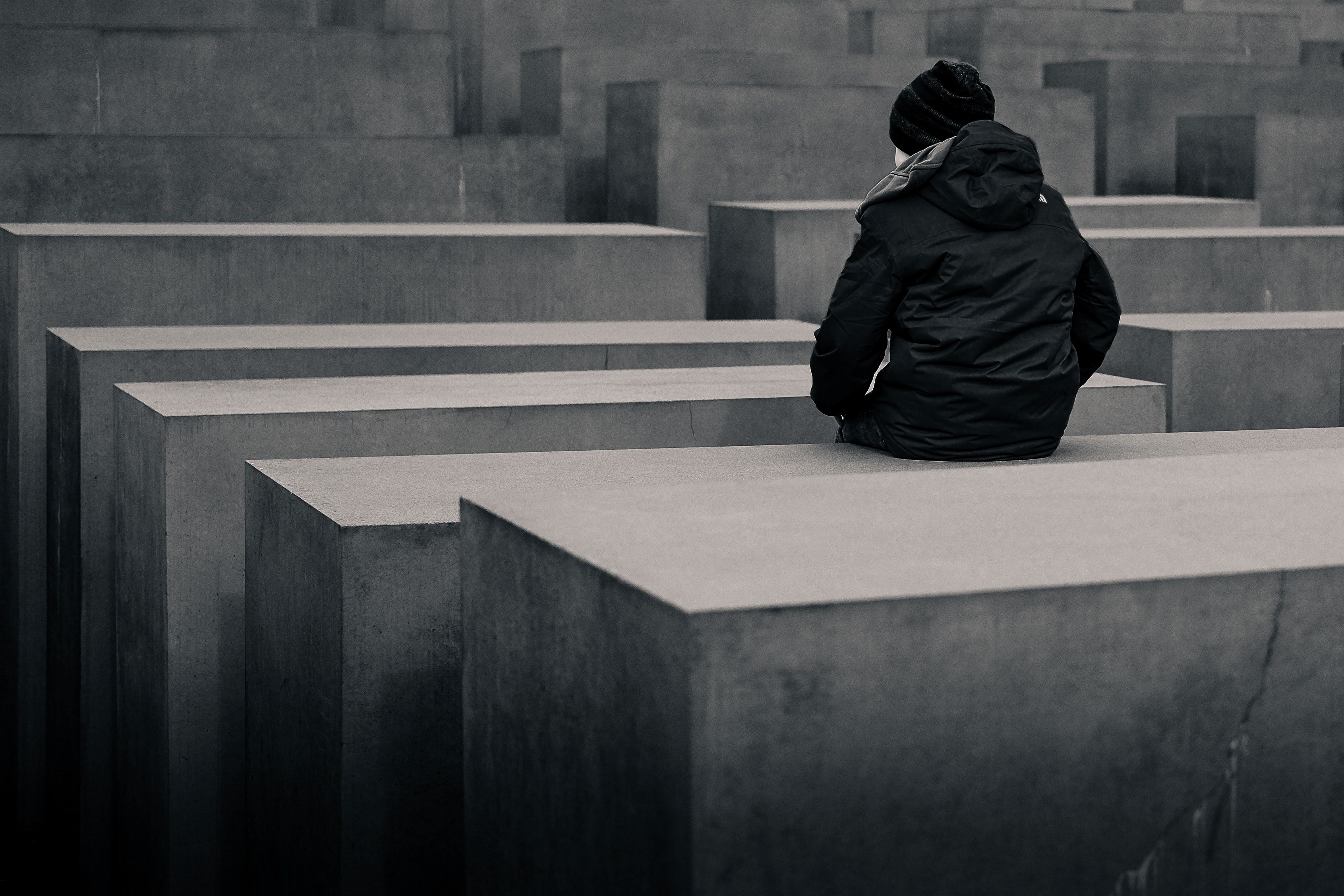 a man in jacket sits on a concrete block among the rows of concrete structures, _up alone 4k, HD Wallpaper