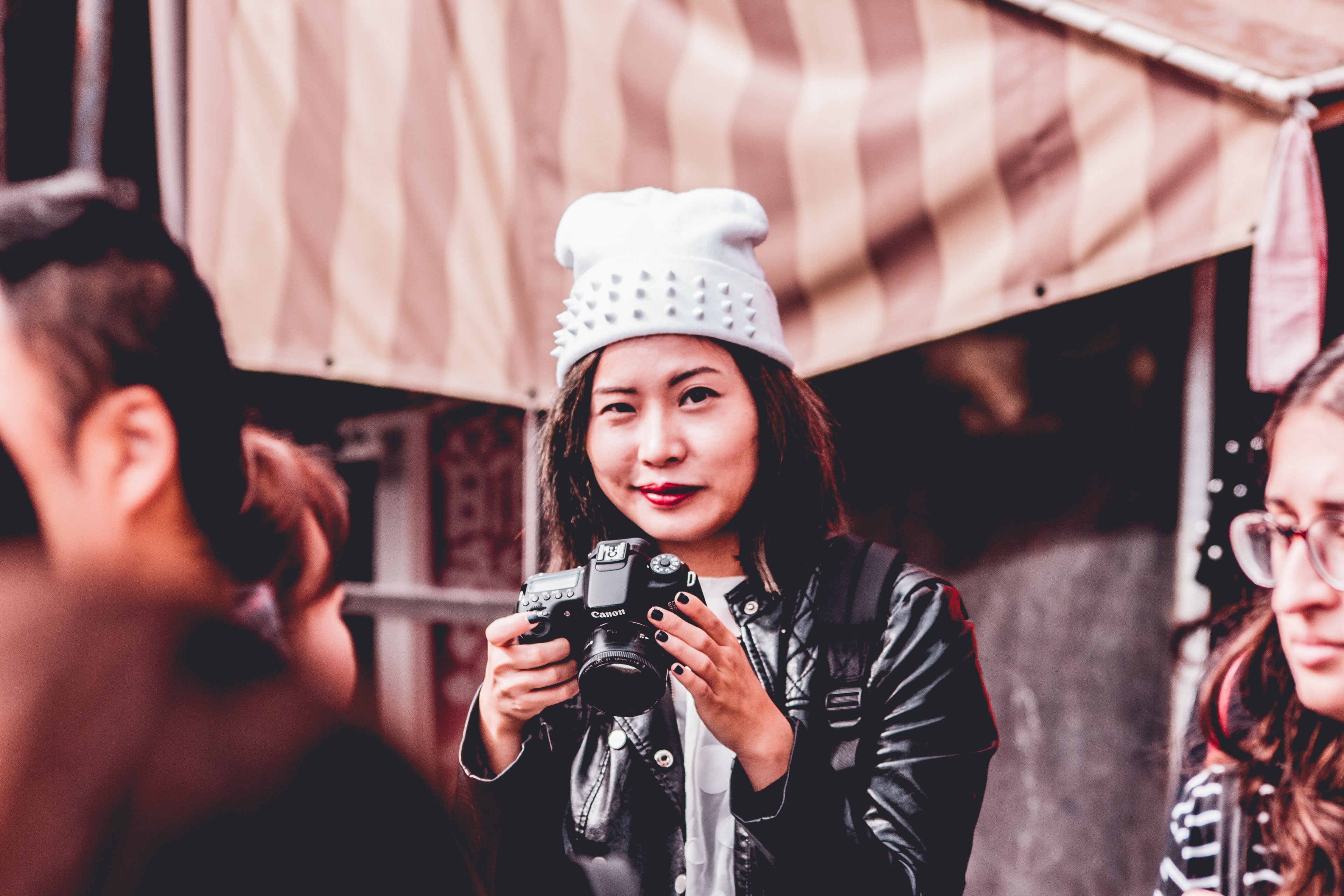 smirking photographer in a white hat and leather jacket holds a camera in a kyoto market, smirking photographer in kyoto 4k, HD Wallpaper