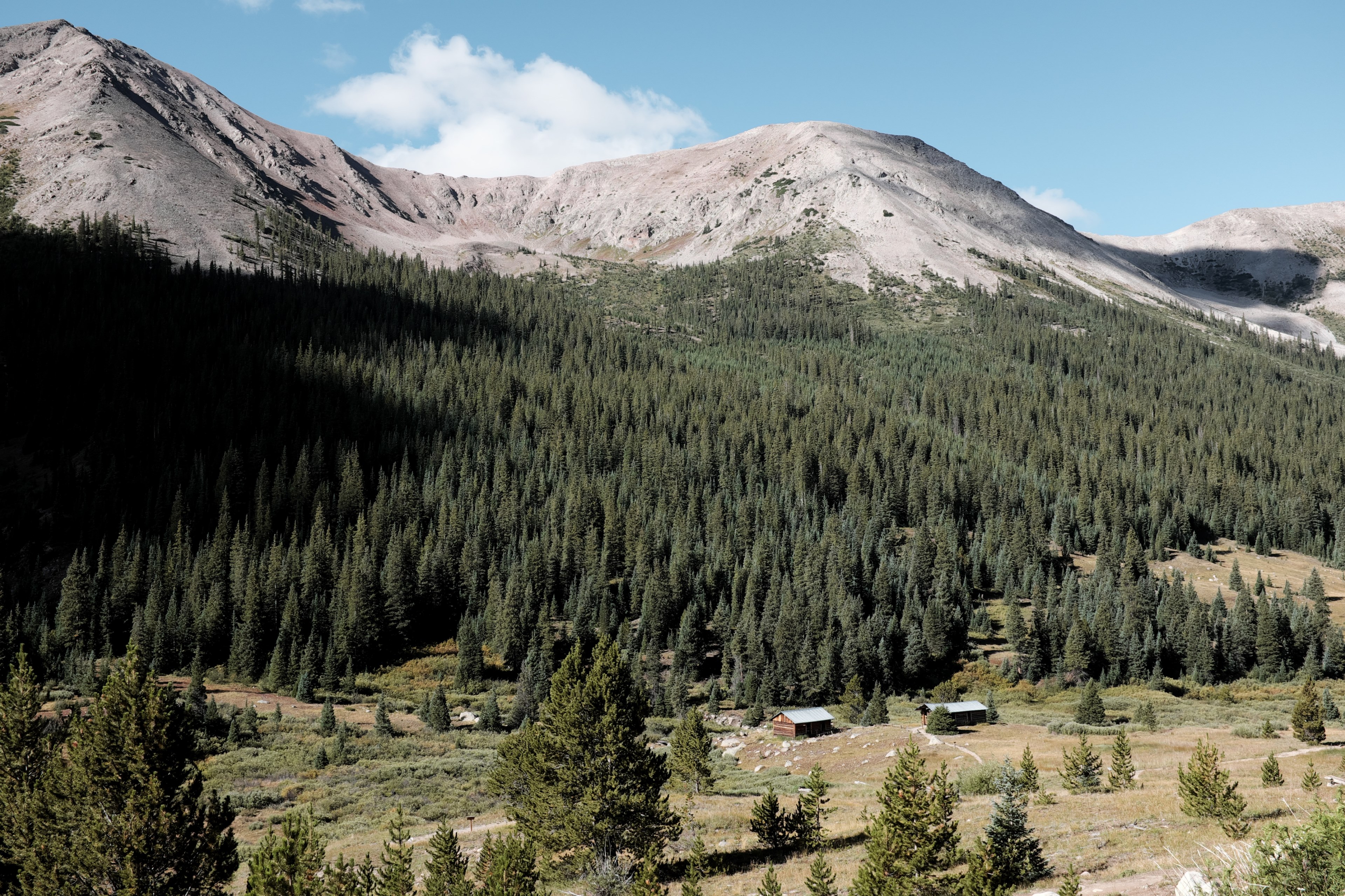 two cabins on the wooded slope of a smooth granite mountain in colorado, 10000 ft 4k, HD Wallpaper