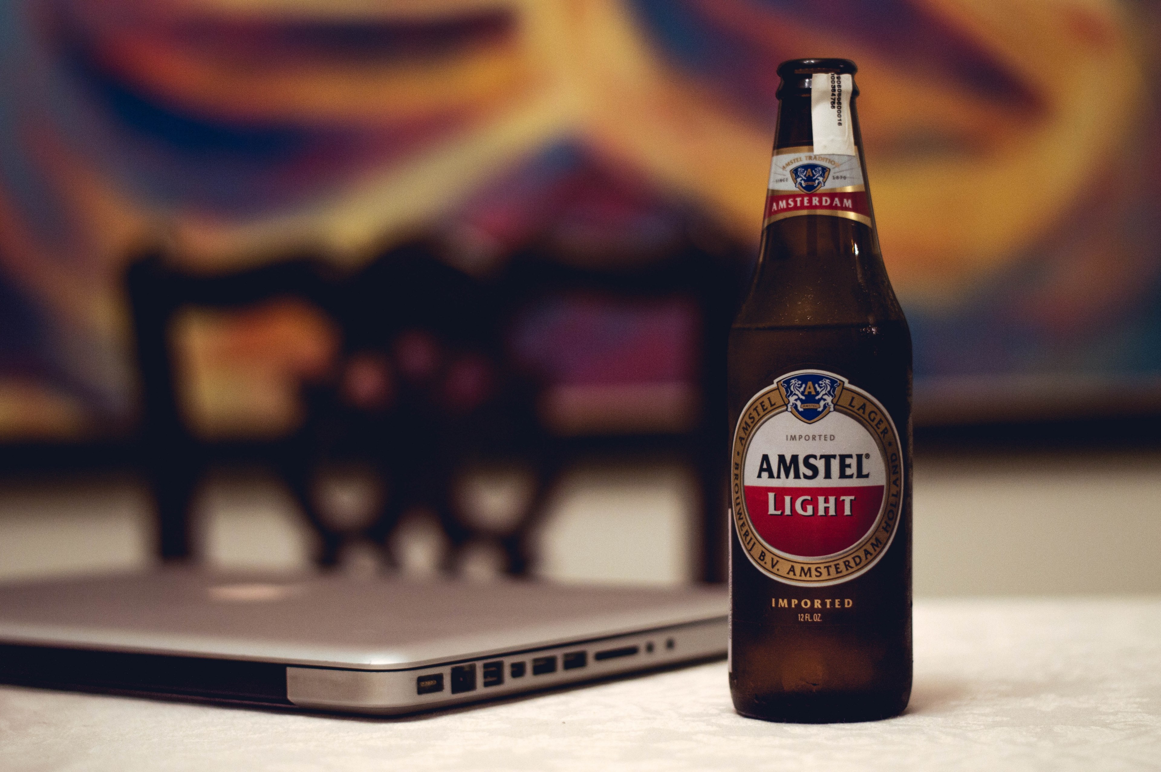an amstel light beer placed next to an apple macbook laptop in new delhi, amstel at work 4k, HD Wallpaper