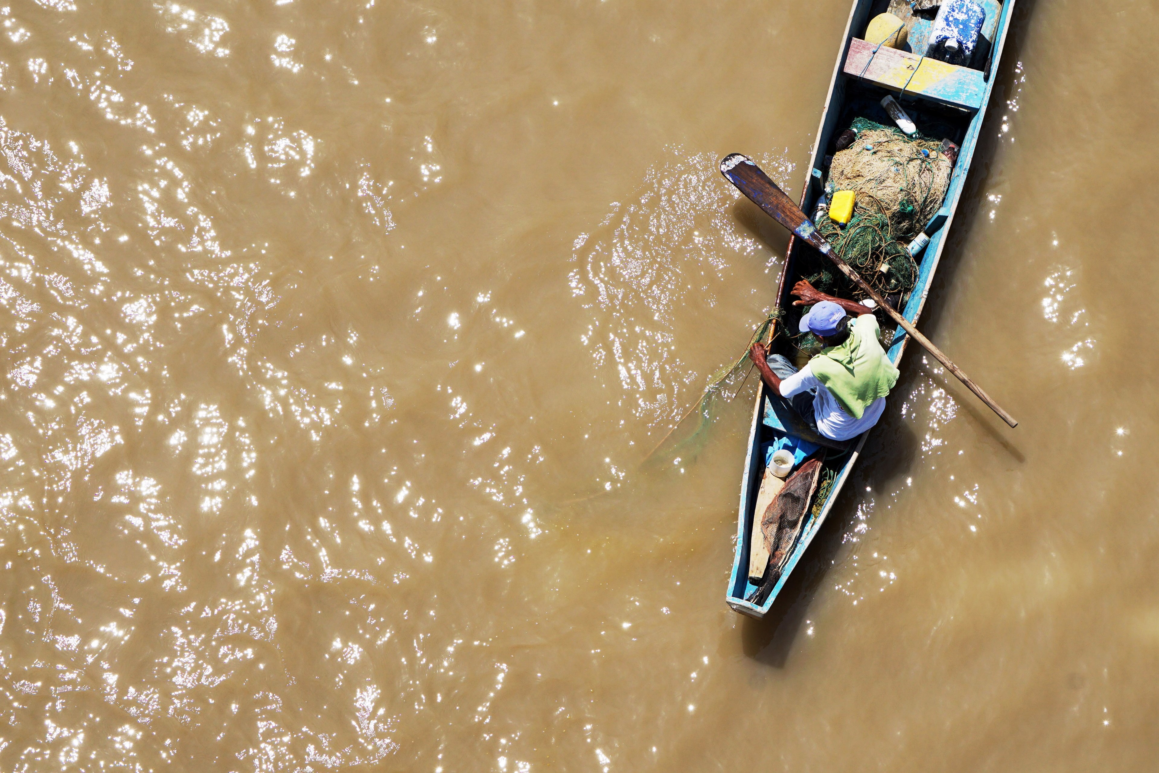 a drone shot of a fisherman on a boat pulling out a fishing net from the water, fisherman at work from above 4k, HD Wallpaper