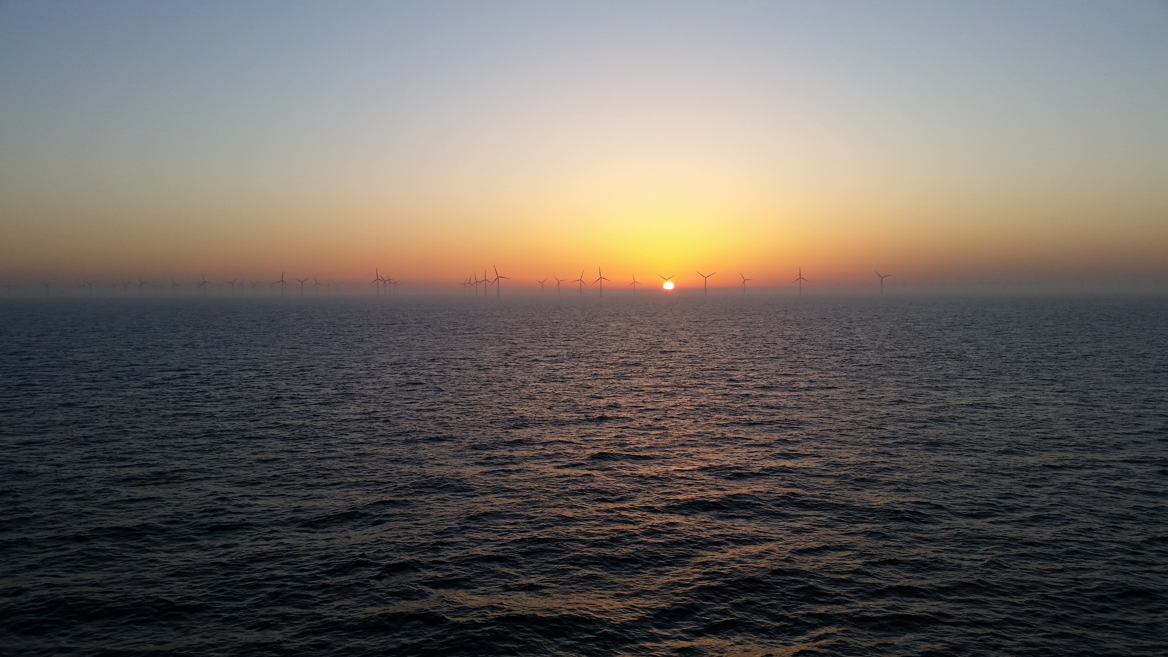 view of the sea during sunset and wind turbines visible at the horizon, windmills on the horizon 4k, HD Wallpaper