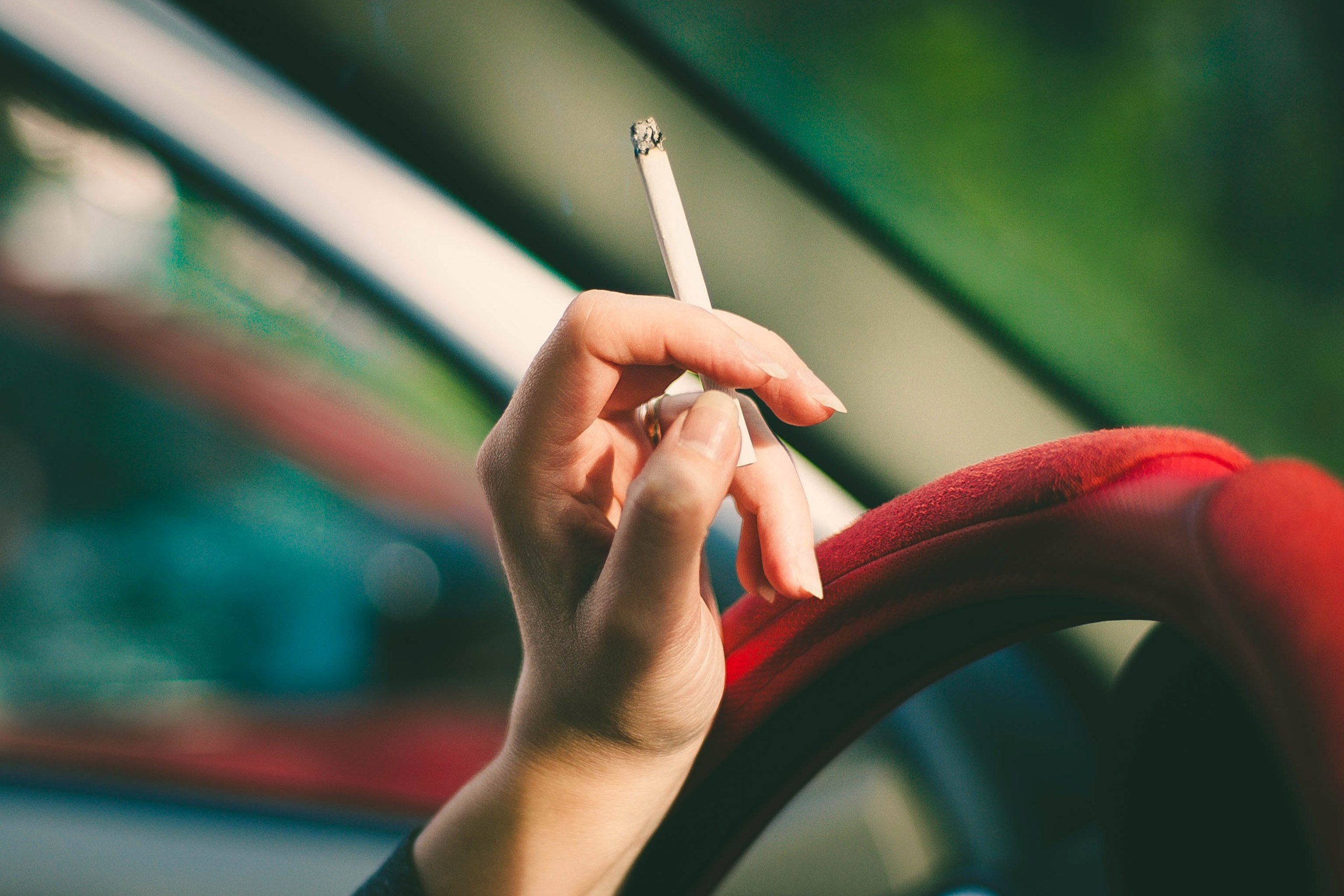 a woman holding a cigarette in a red car, cigarette in car 4k, HD Wallpaper