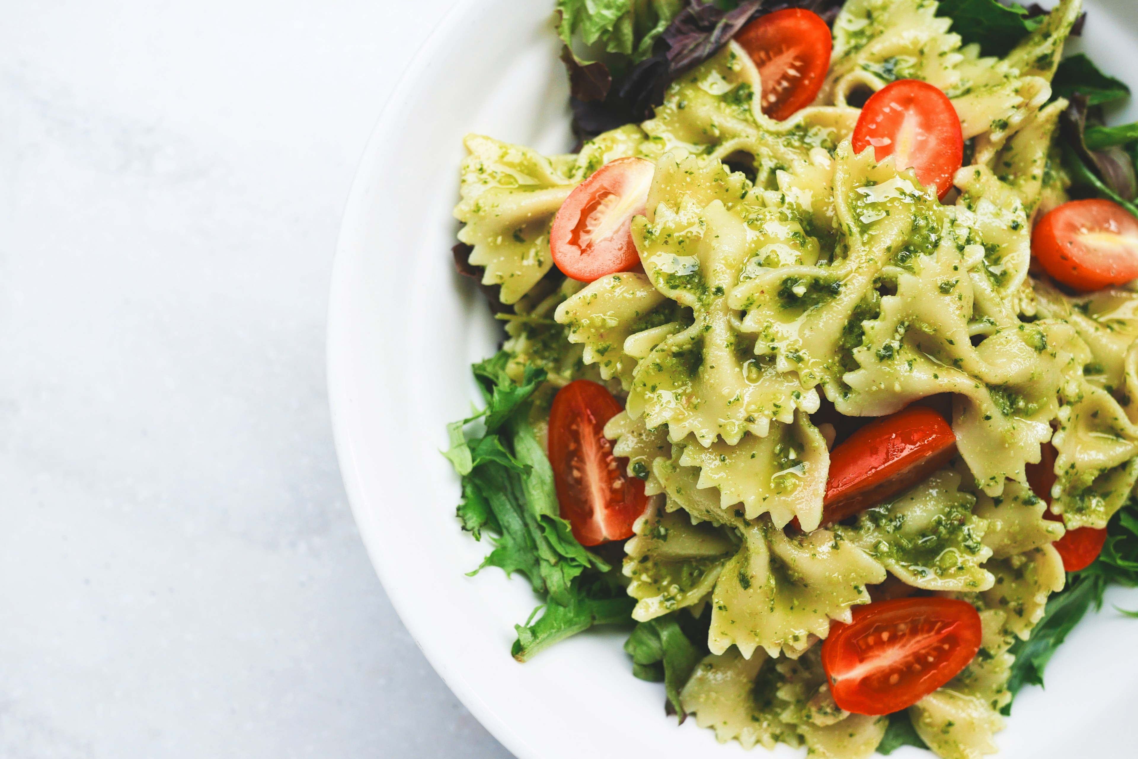 a plate of bow tie pasta cherry tomatoes lettuce and pesto sauce at bunas kitchen, pesto pasta 4k, HD Wallpaper