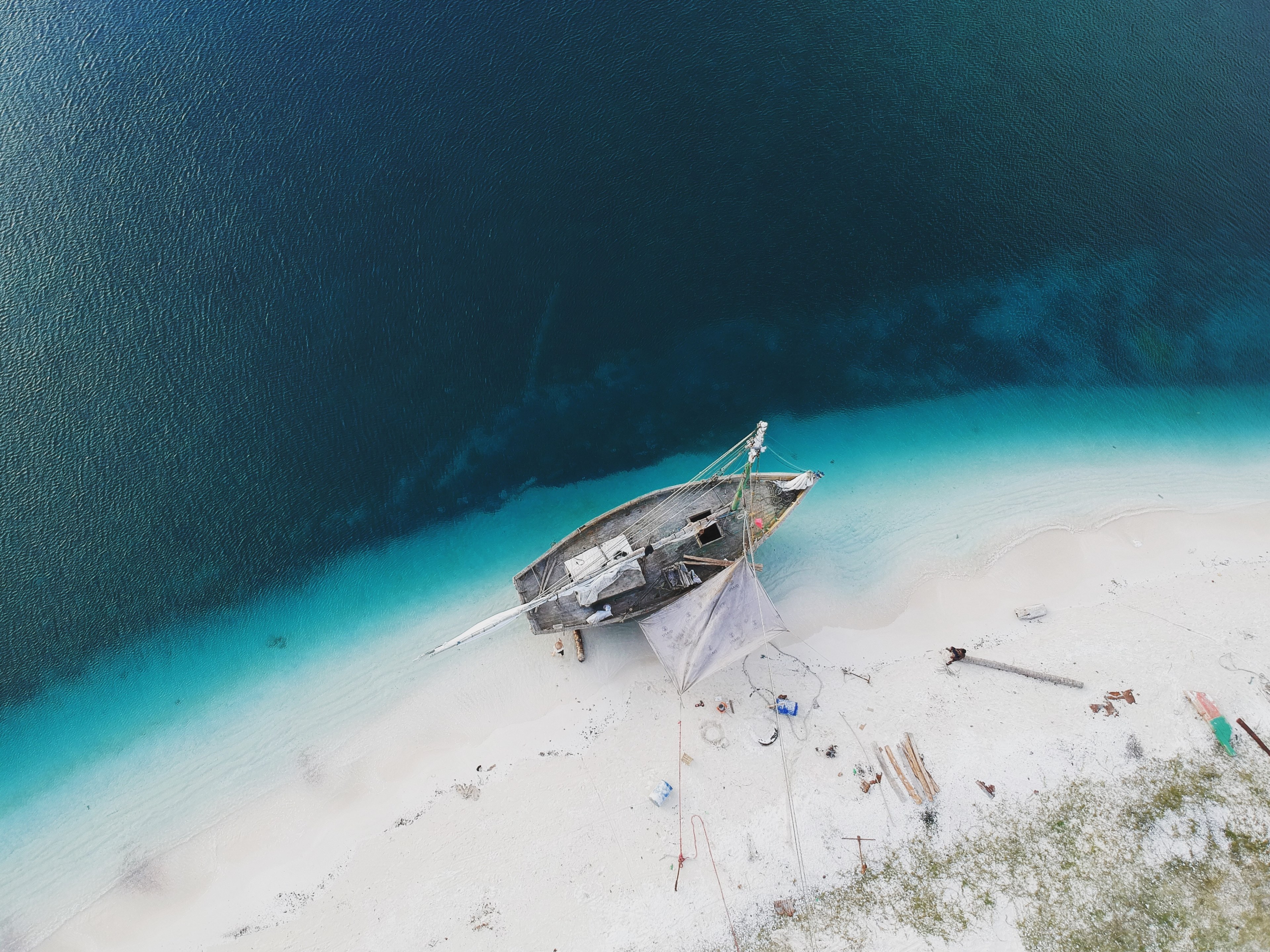 drone aerial view of the boat being repaired on the sand beach in pointe figuier sud department haiti, baie du mesle haiti 4k, HD Wallpaper