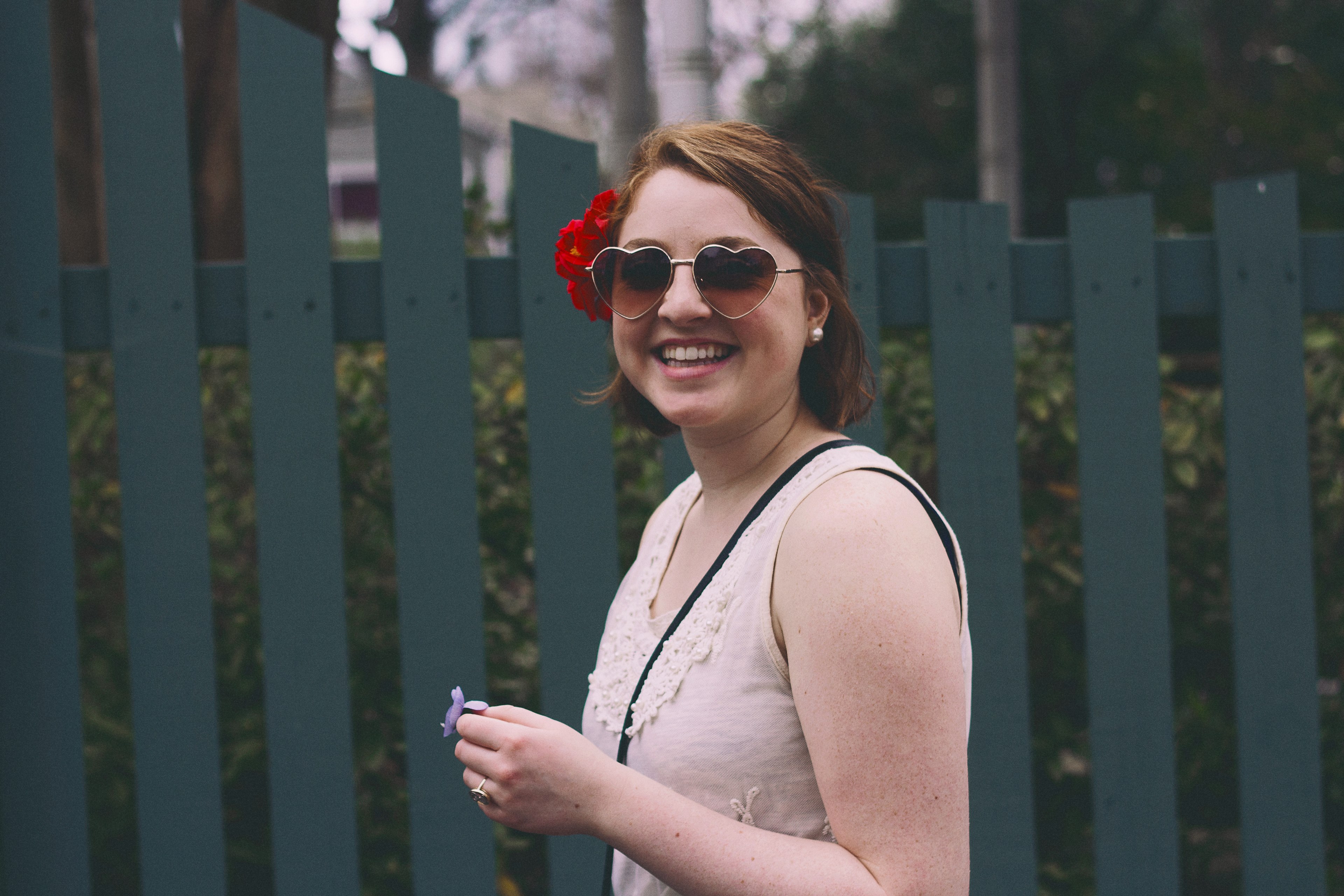 a smiling woman in heart shaped sunglasses with red flowers in her hands, joyful woman in heart sunglasses 4k, HD Wallpaper