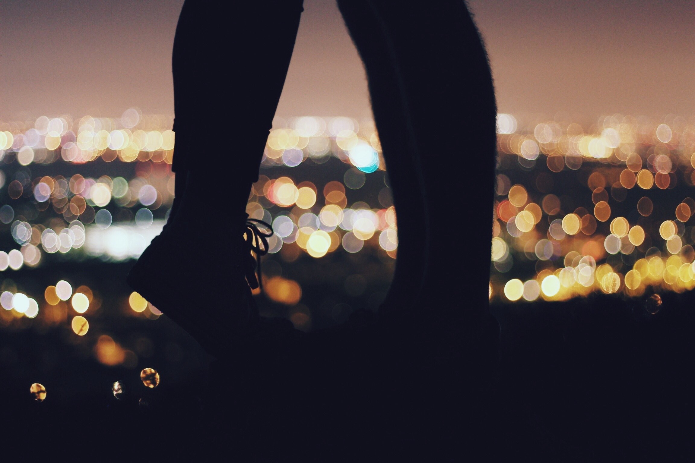 illuminated by the lights of the city below a woman rises on tip toes to kiss her boyfriend, kiss above the city 4k, HD Wallpaper