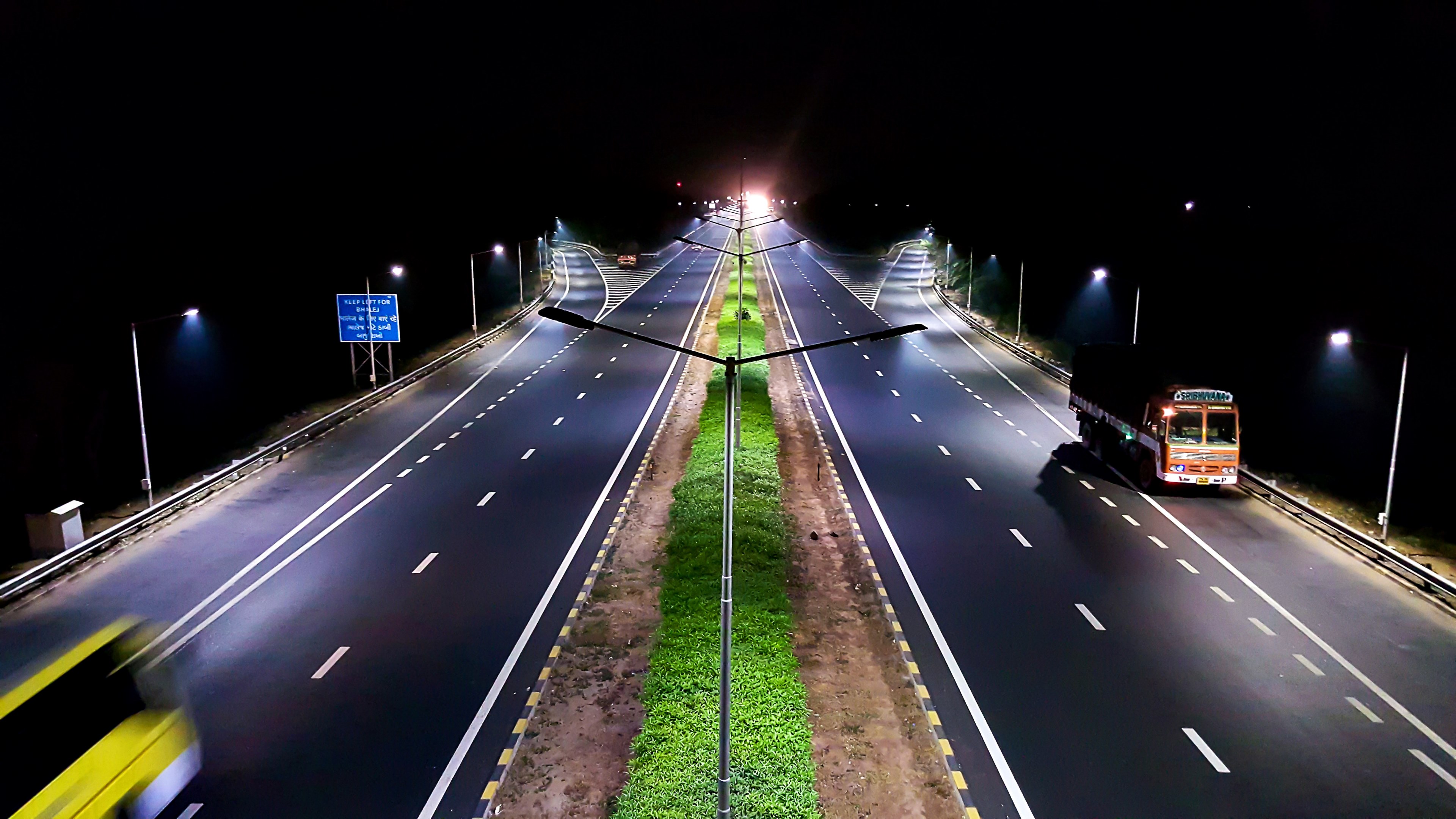 a relatively empty dual highway illuminated by artificial light at night, roads 4k, HD Wallpaper