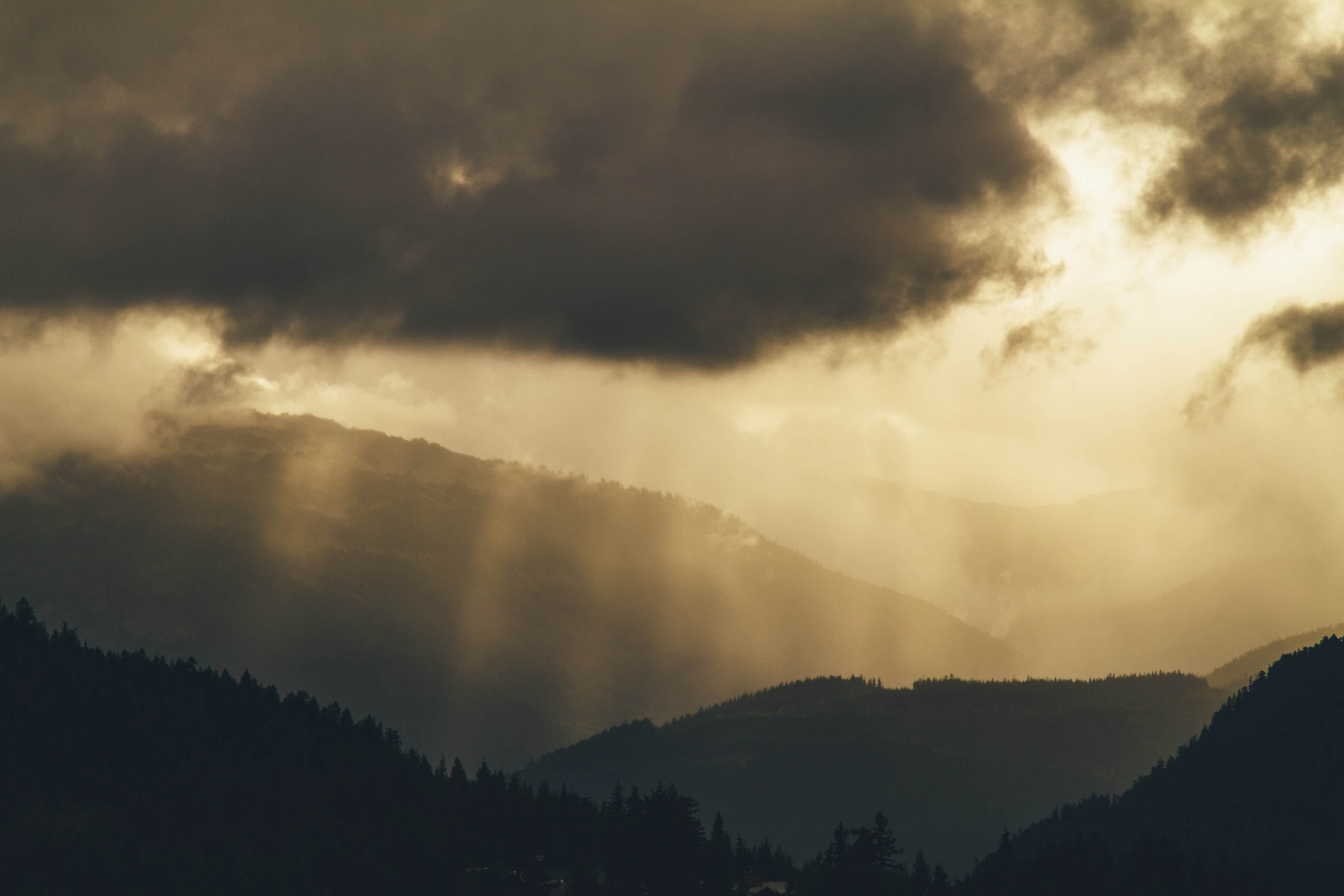 wooded hills behind a thick haze on a cloudy day, faint sun rays over hills 4k, HD Wallpaper