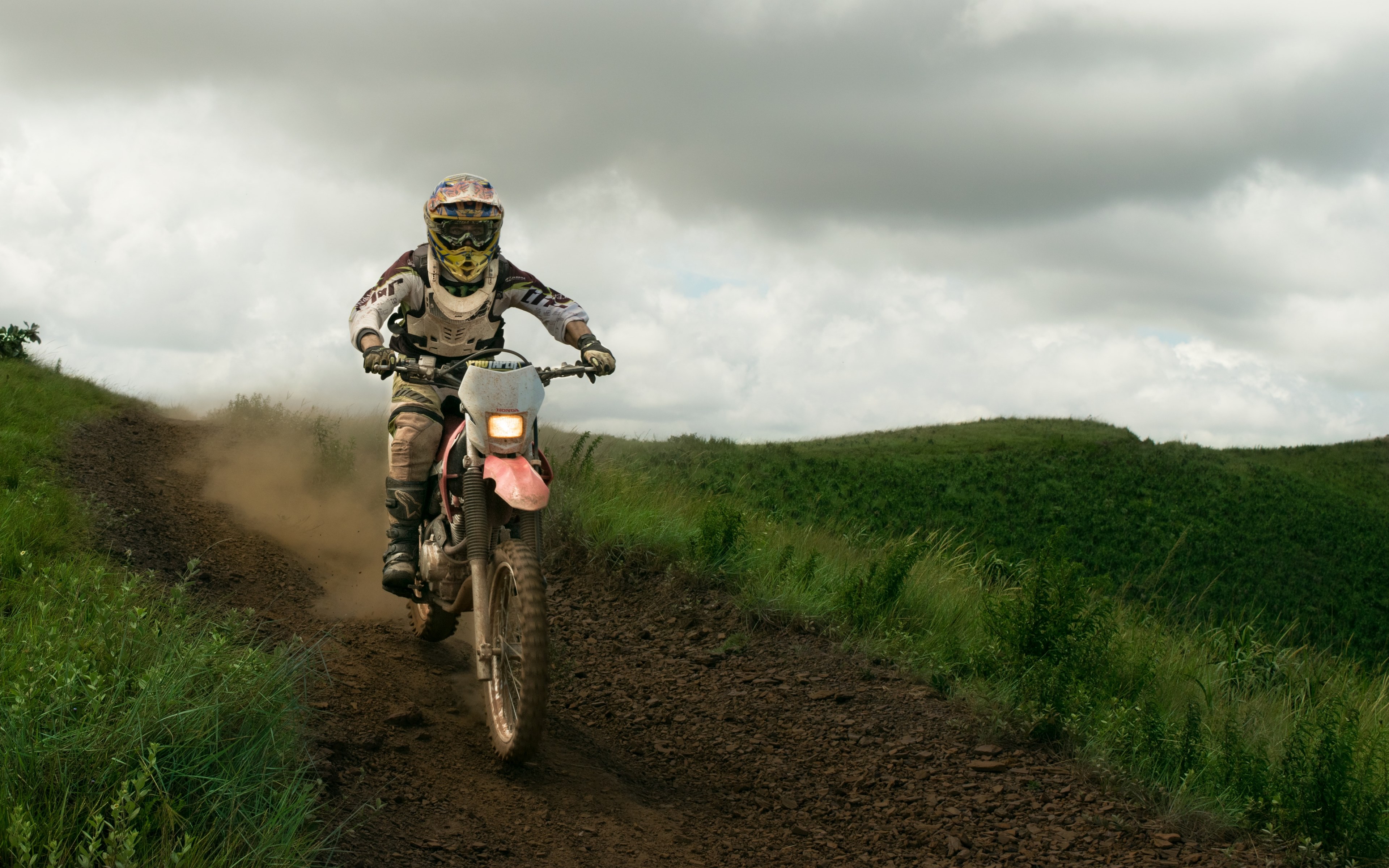 a motocross driver wearing protective gear and a helmet on a motorcycle in brumadinho, motorbike dirt road 4k, HD Wallpaper