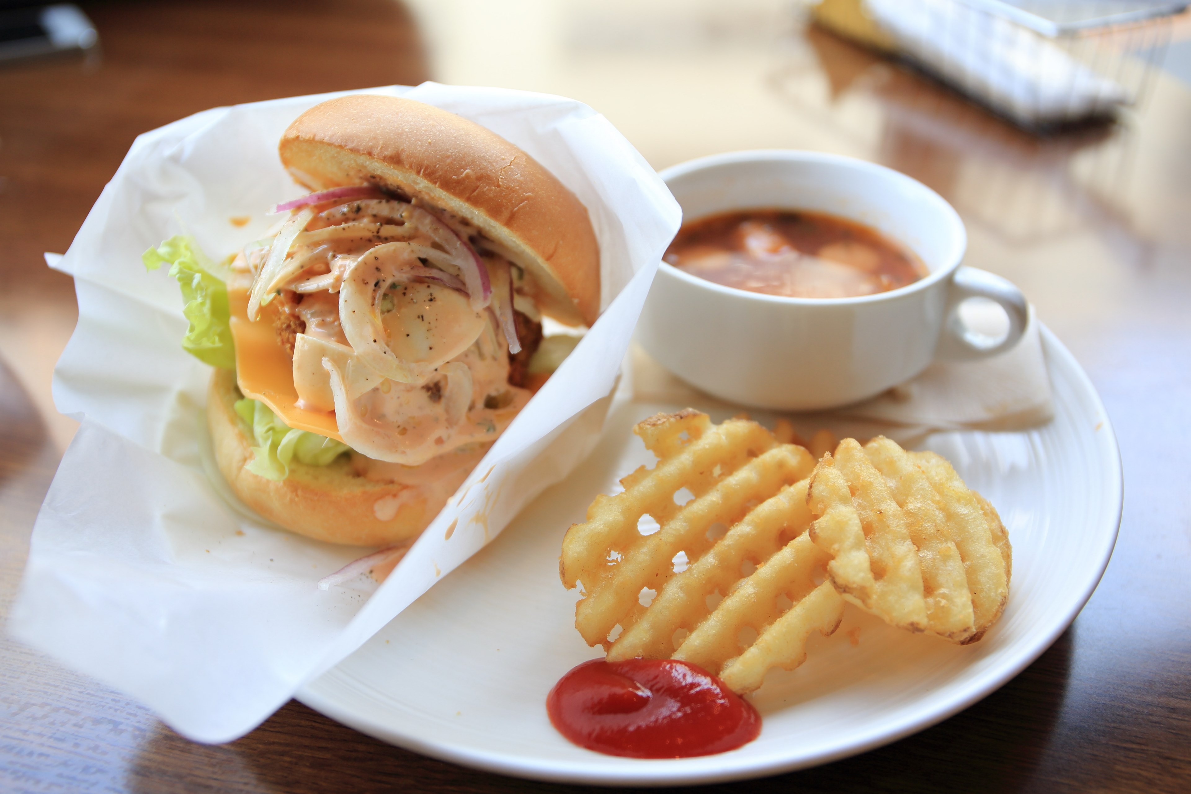 burger on a plain bun with onions american cheese lettuce and sauce with a side of waffle fries and soup in a mug, lunch at a diner 4k, HD Wallpaper