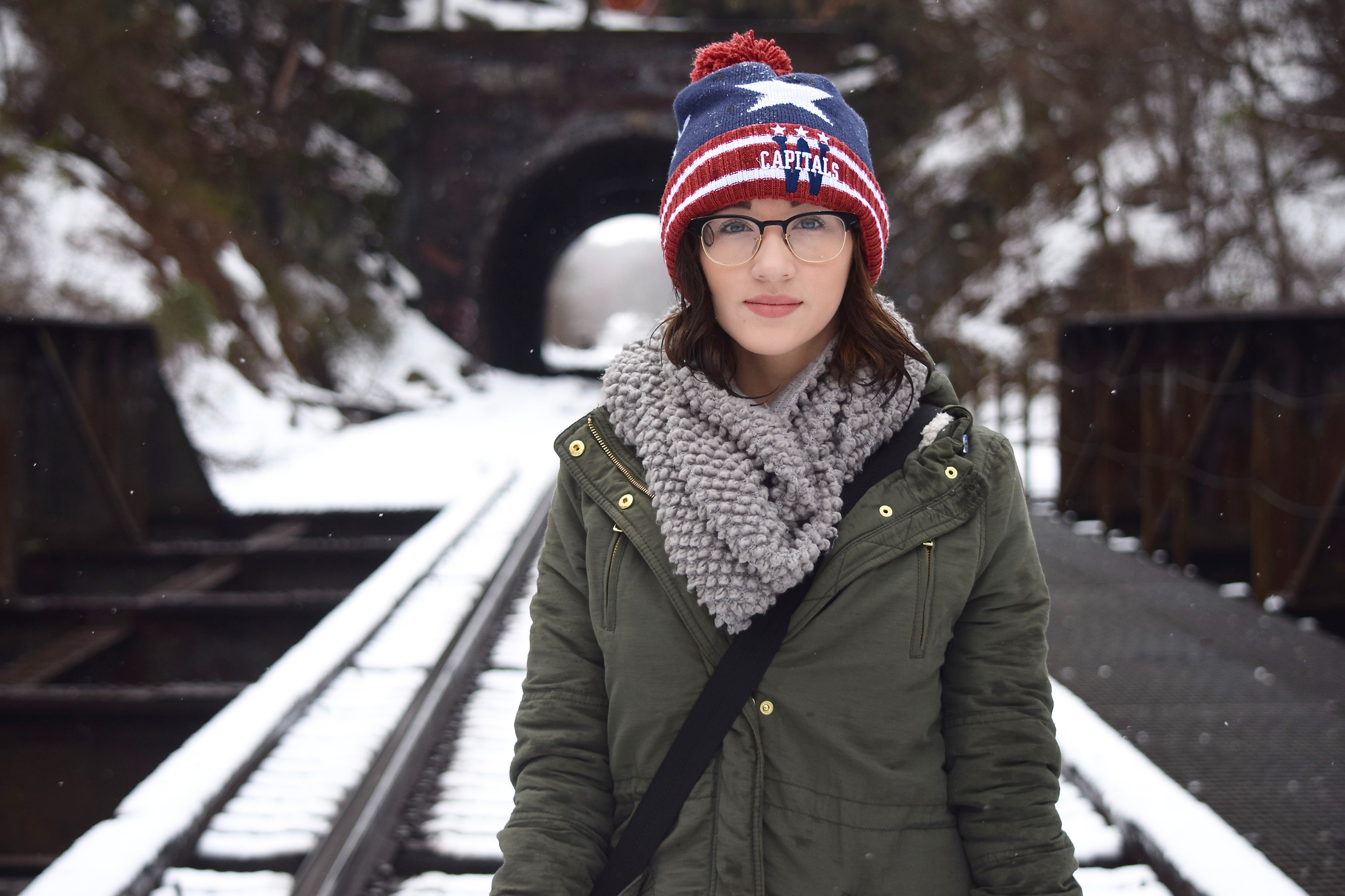a girl with is walking on a snowy train track in front of a tunnel, woman on train tracks 4k, HD Wallpaper