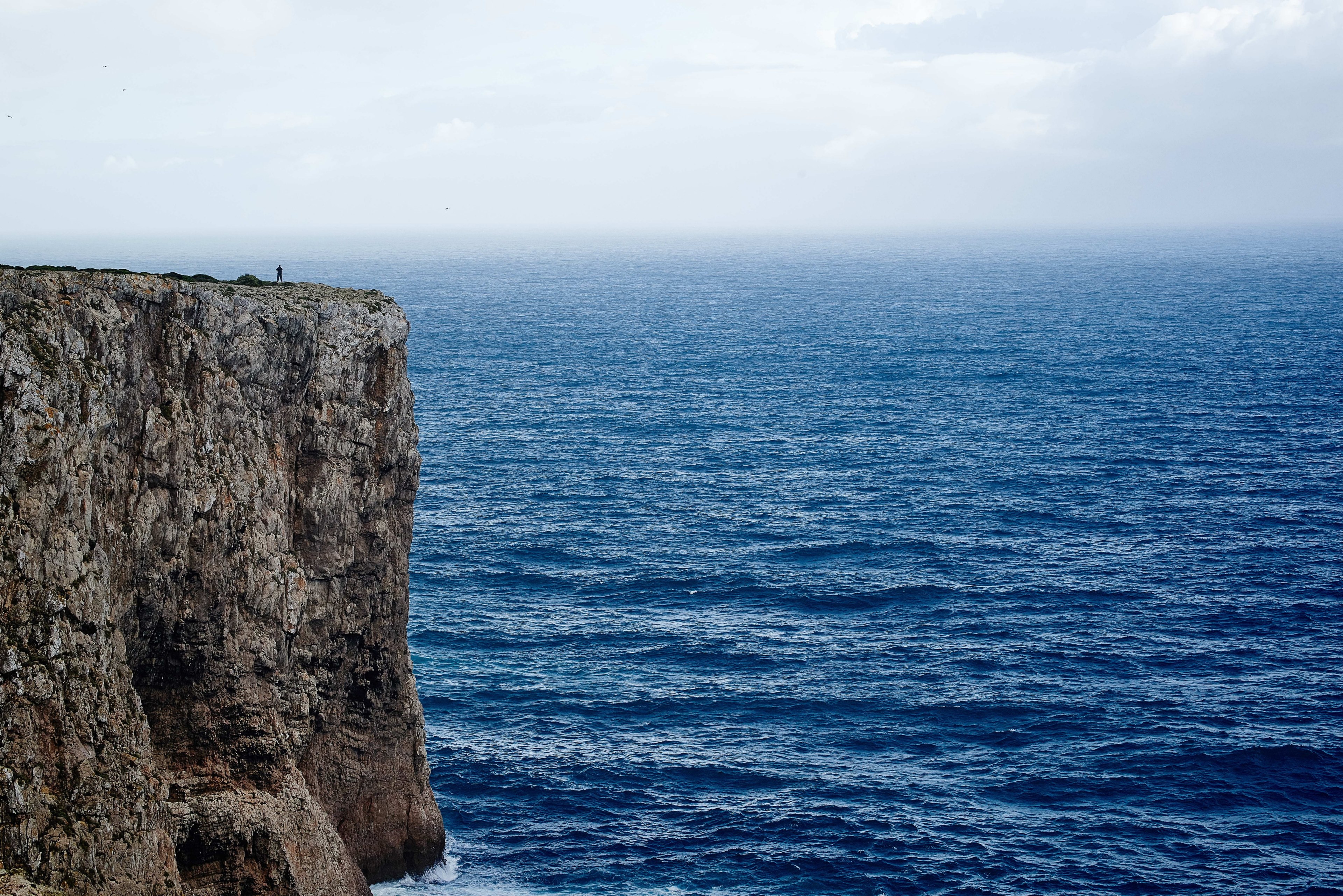 a rocky cliff overlooking a brilliant blue sea at sagres, rock over the sea 4k, HD Wallpaper