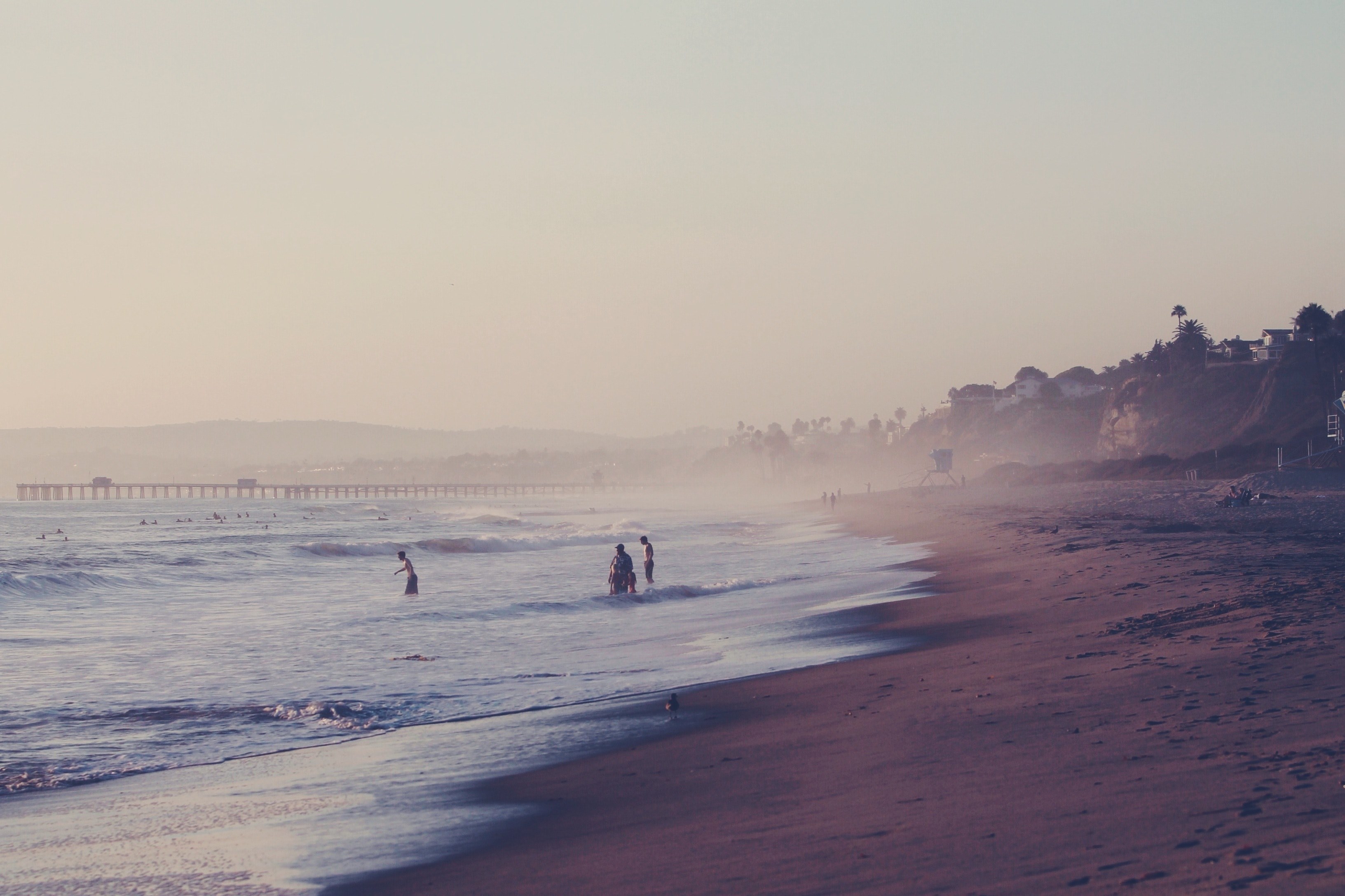 people swimming at the beach by the sea shore with tide and a bridge in the background, _swimming at the beach 4k, HD Wallpaper