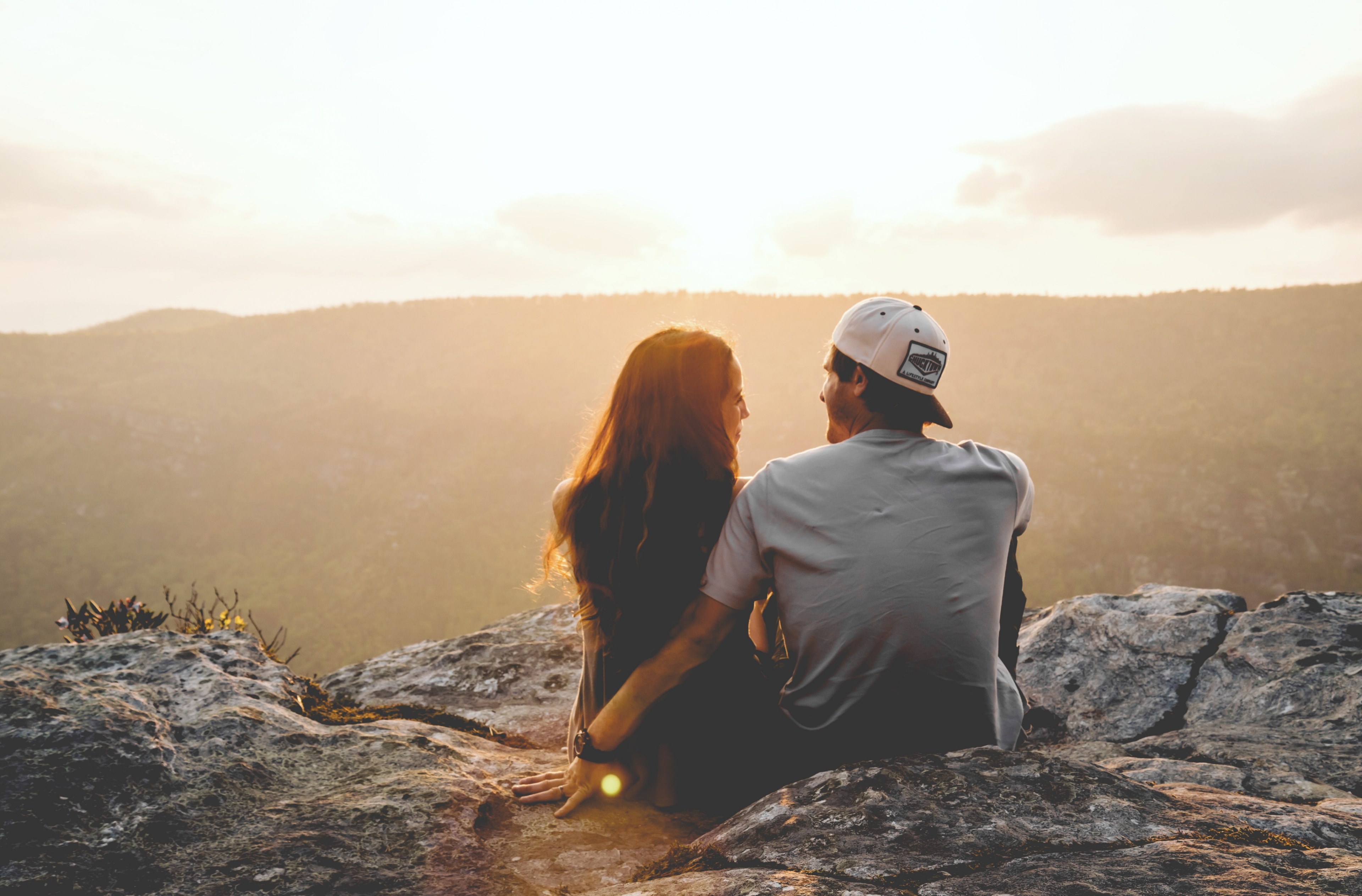 couple sitting on a rocky mountain looking at each other as sunset colors the sky, with your friends 4k, HD Wallpaper