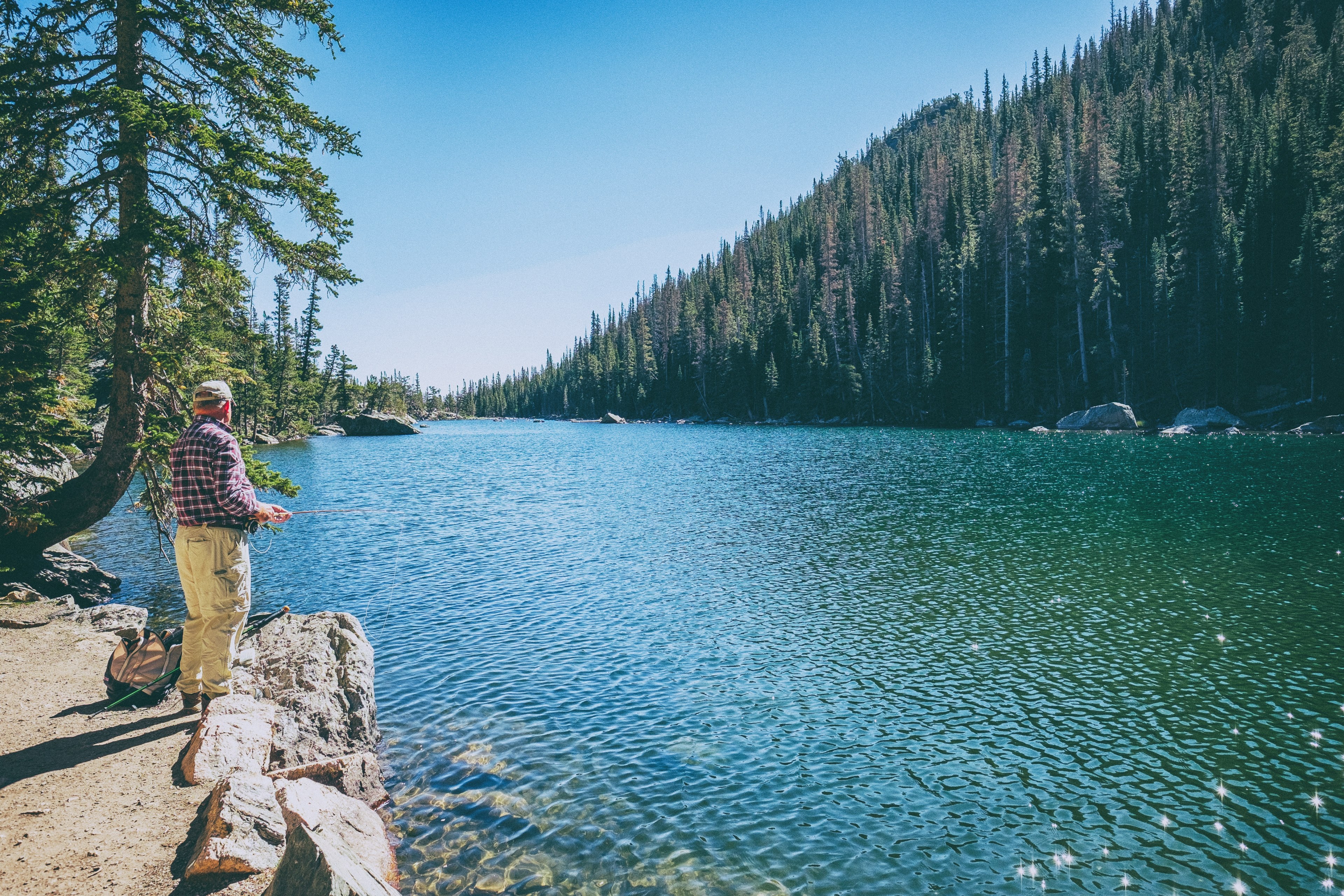 a man with a fishing pole on the shore of emerald lake, fisherman over a lake 4k, HD Wallpaper