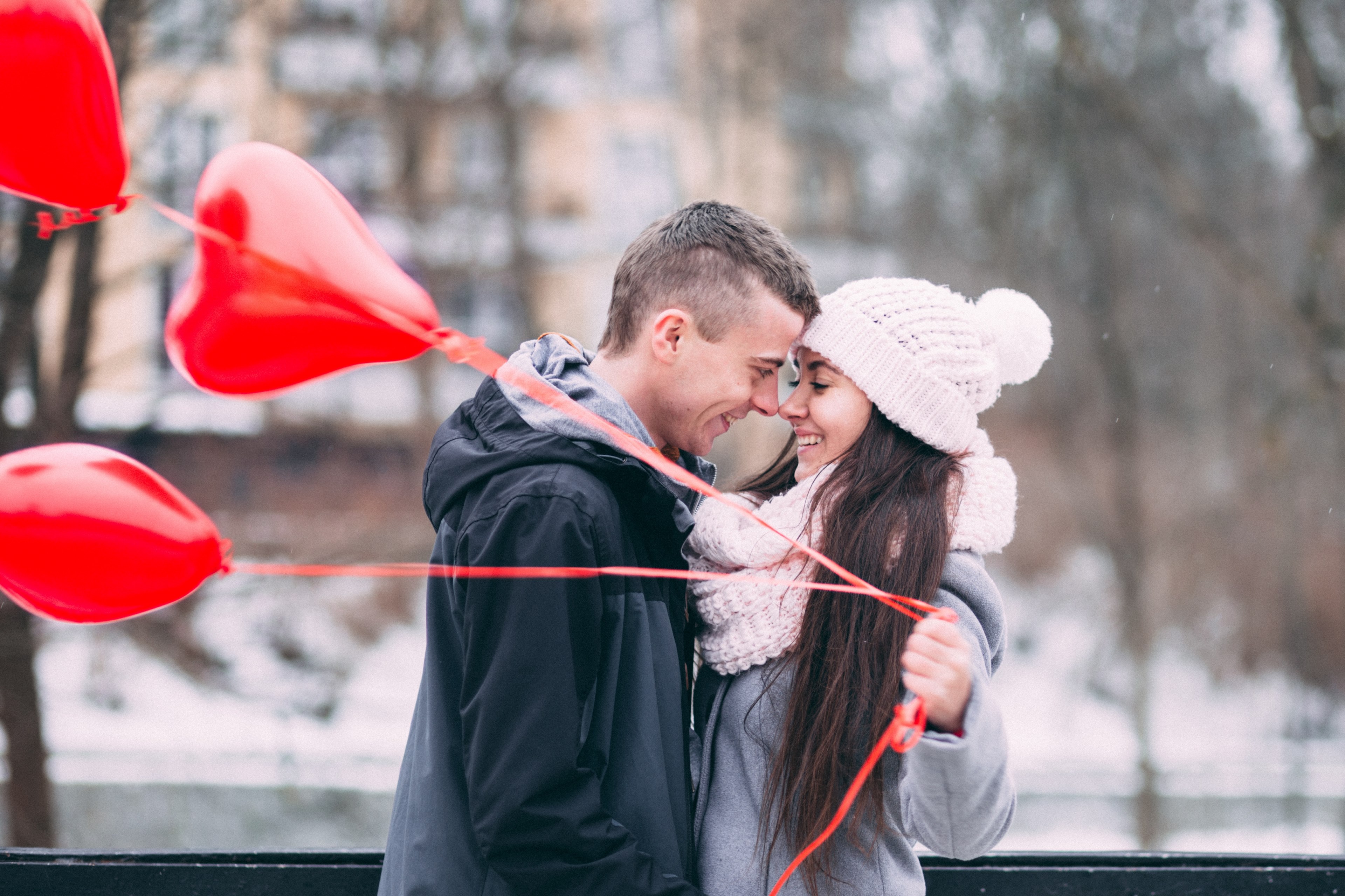 a man and woman smiling while touching face to face as the girl holds red heart shaped balloons, _kissing with heart balloons 4k, HD Wallpaper