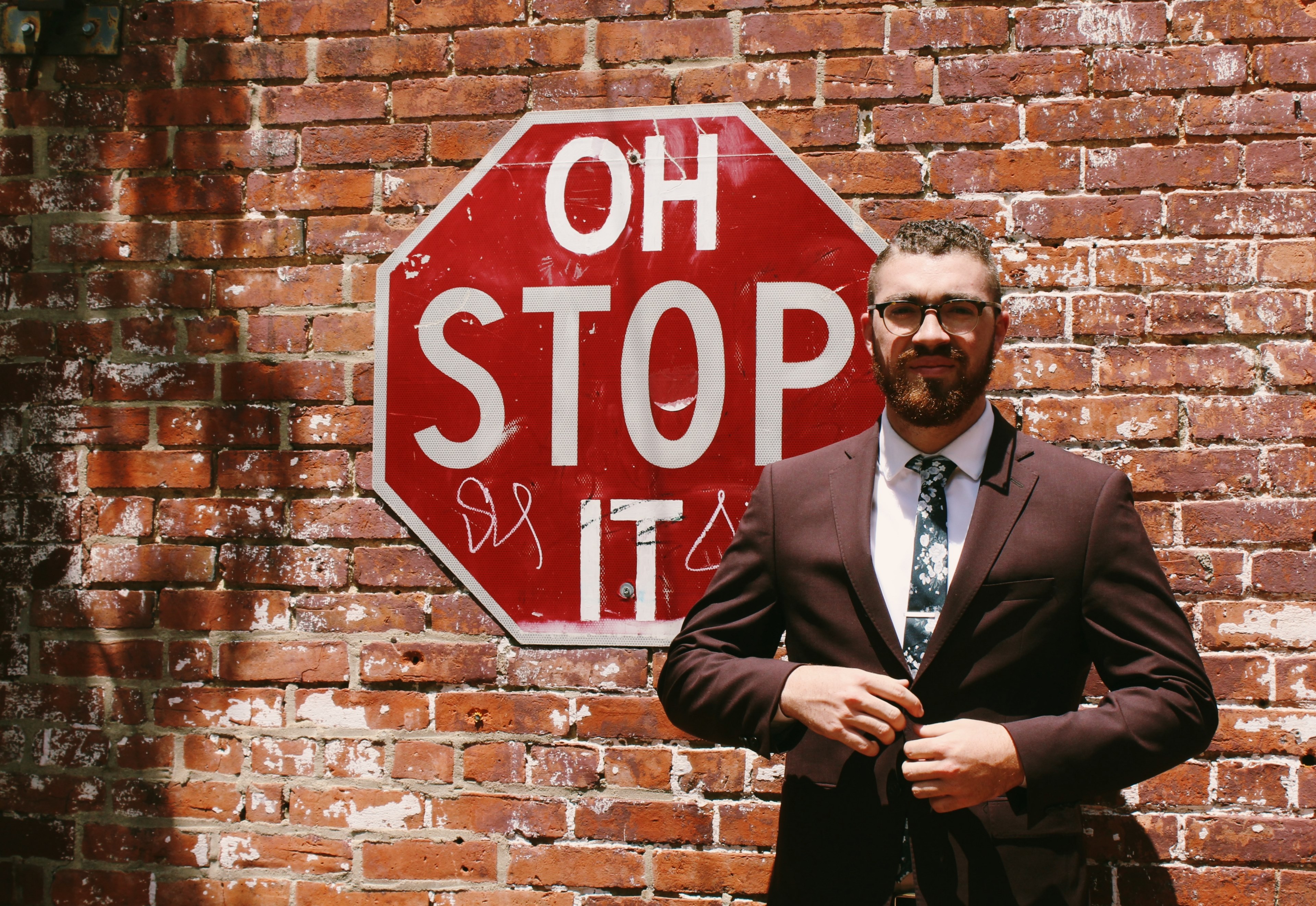 a bearded man in a brown suit in front of a brick wall with a red stop sign, oh stop it 4k, HD Wallpaper