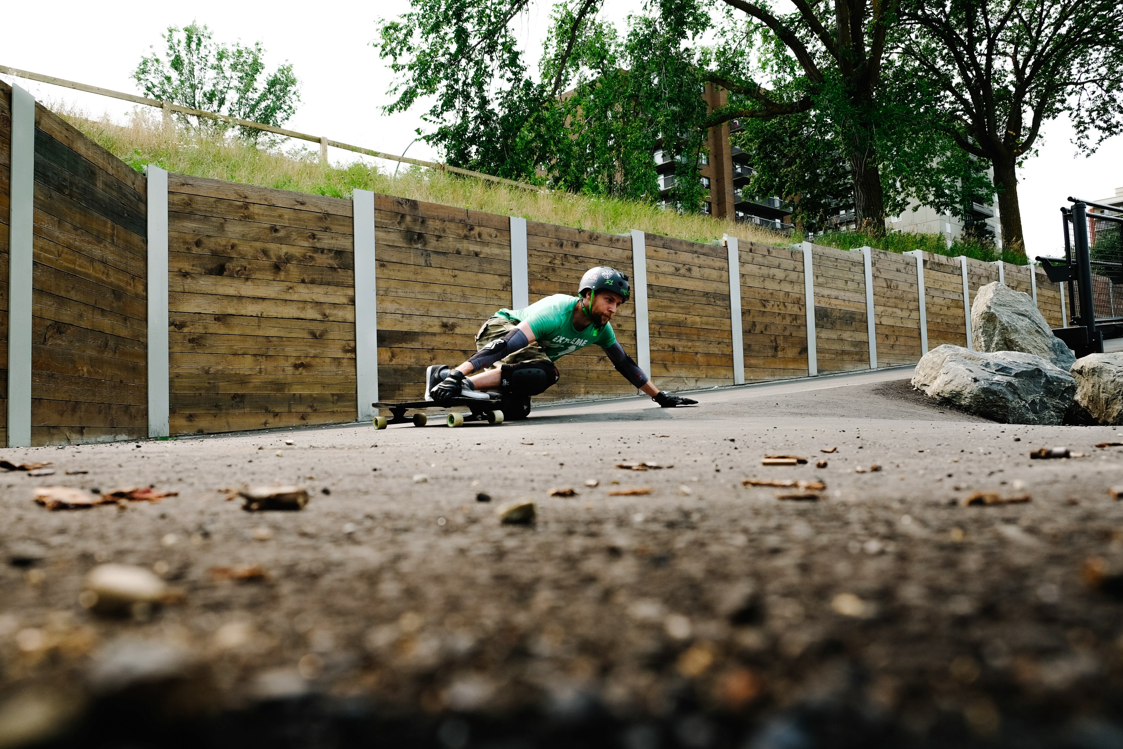 a skateboarder in a helmet does a trick on a sloping surface beside a wooden wall, afternoon shredding 4k, HD Wallpaper