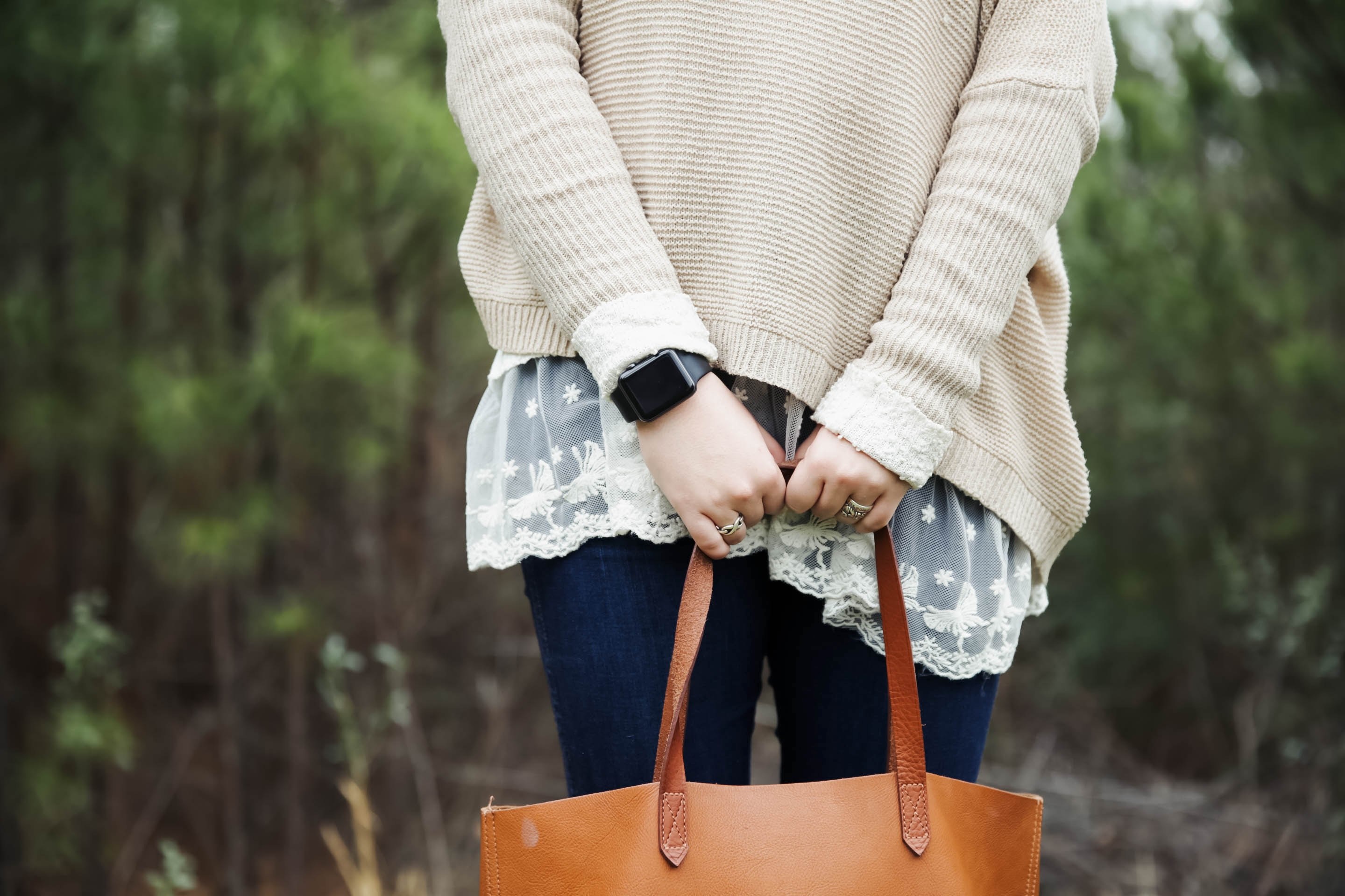 a woman wearing a sweater and an apple watch holding a leather bag in suwanee, holding on 4k, HD Wallpaper