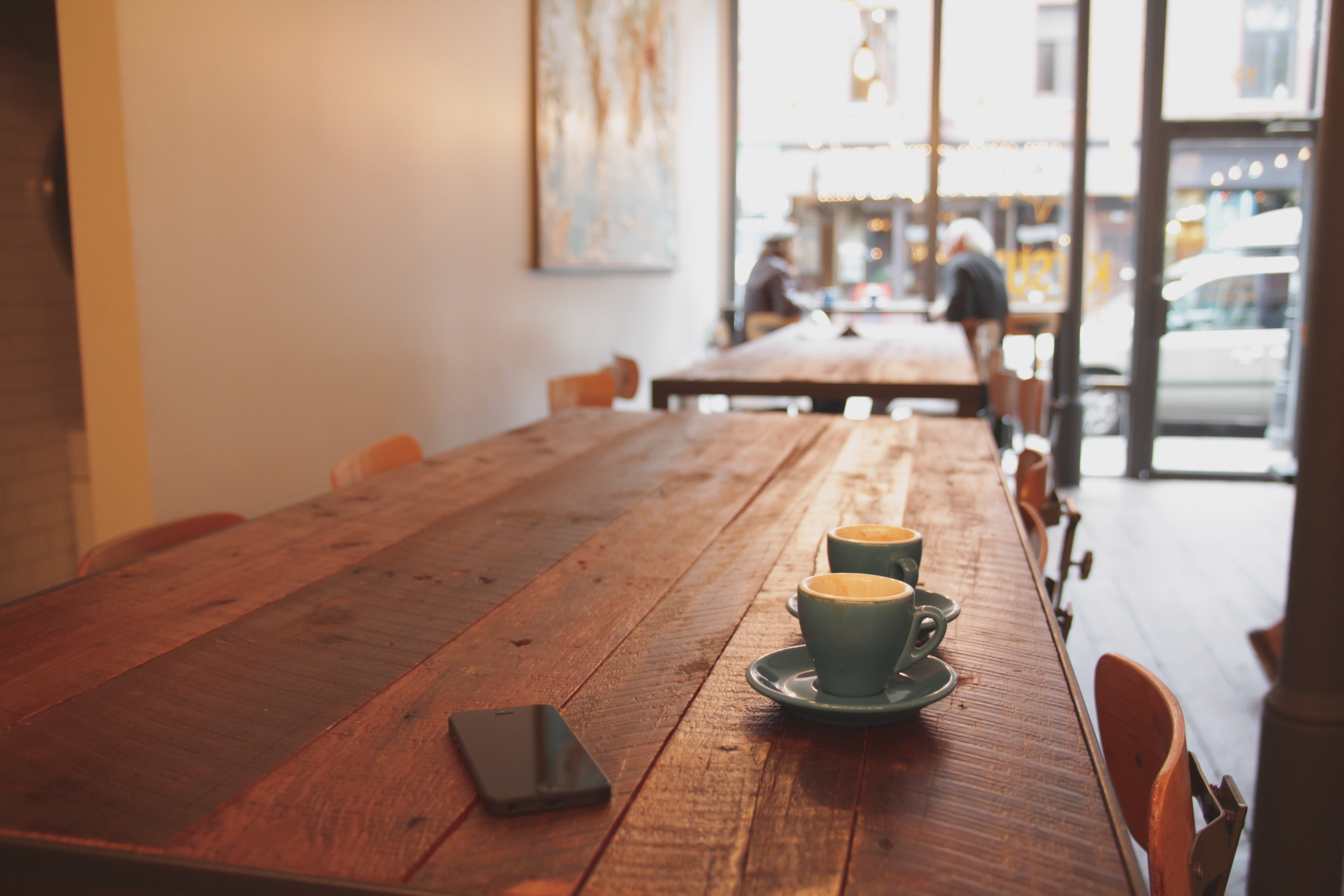 a view of the table top at kitsun caf with two elderly people sitting together in the background, coffee in montreal 4k, HD Wallpaper
