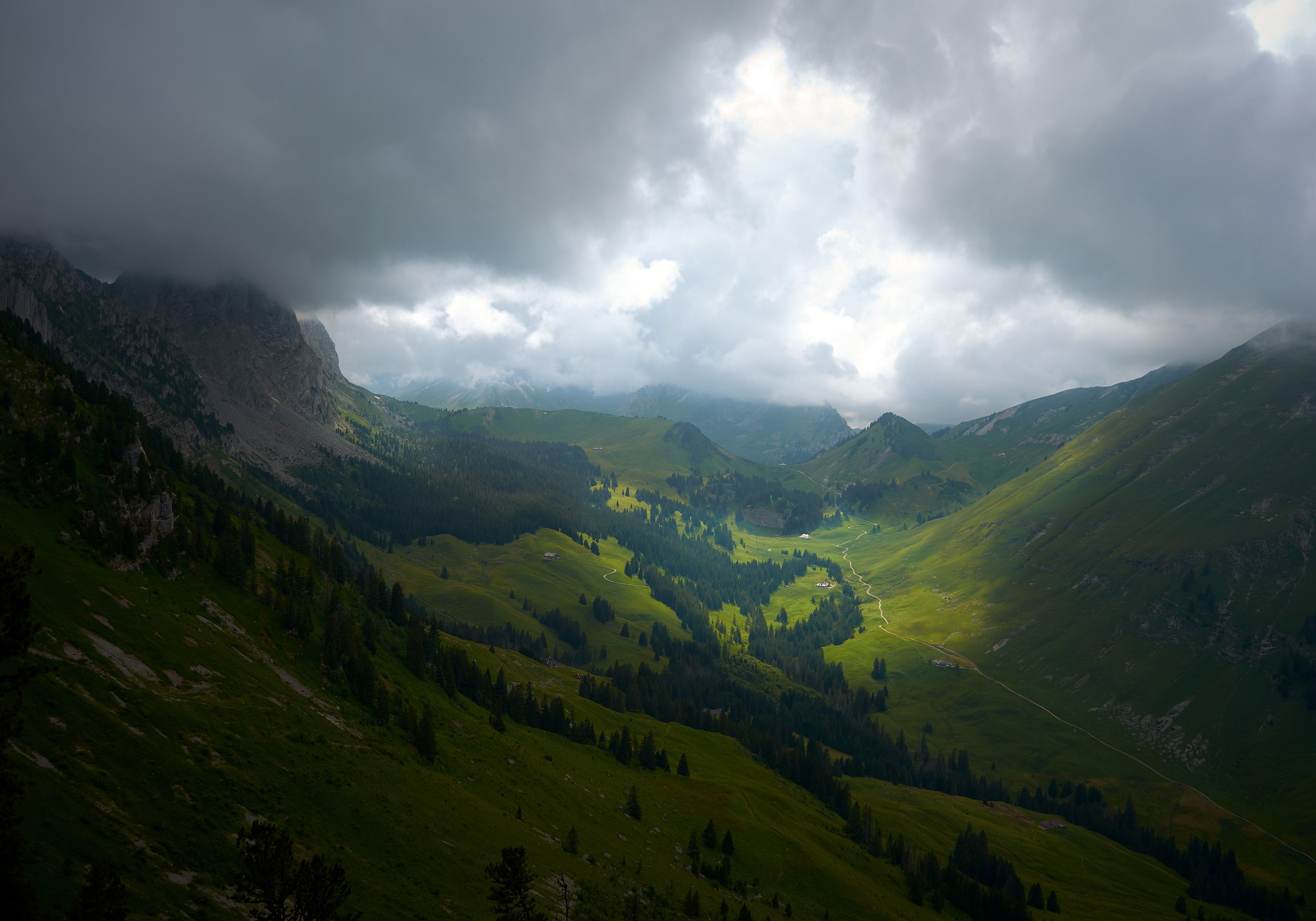 sun shining through the thick clouds illuminates the bottom of a green valley, shadow over mountain valley 4k, HD Wallpaper