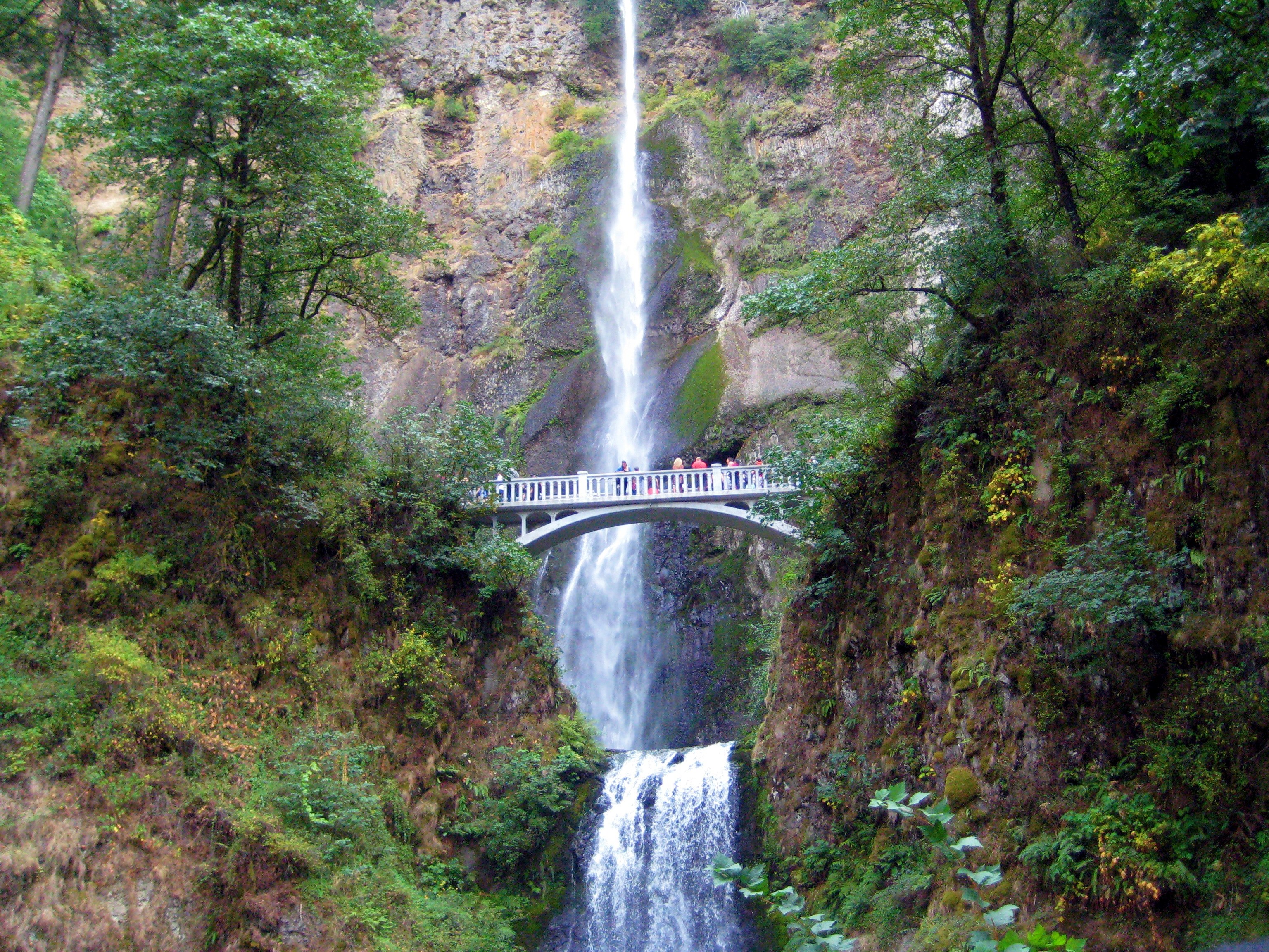 people standing on a white bridge over a waterfall pouring down from a rocky face, people on a white bridge over a waterfall 4k, HD Wallpaper