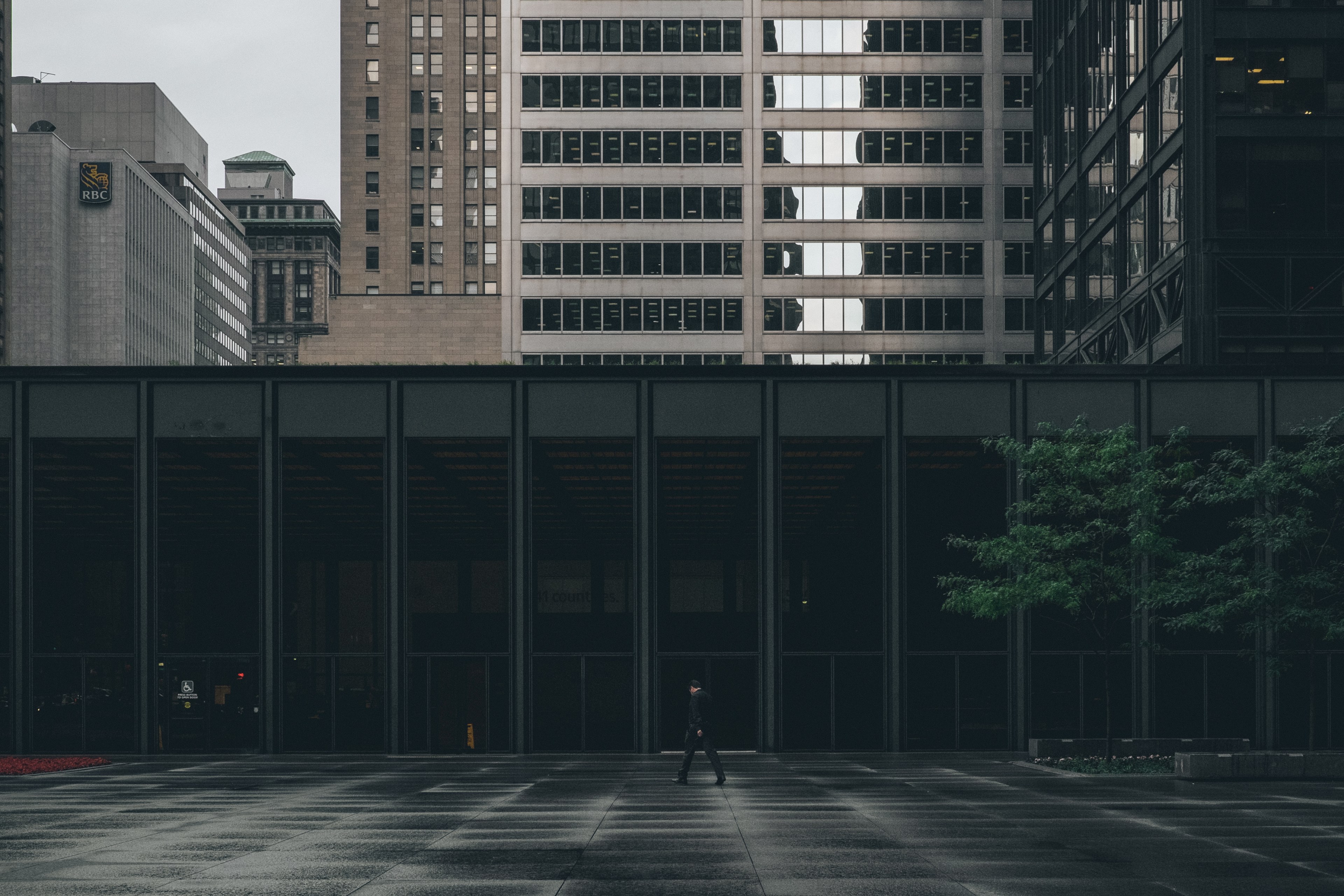 a man in a black suit walking near a building on a rainy day, businessman on a rainy day 4k, HD Wallpaper
