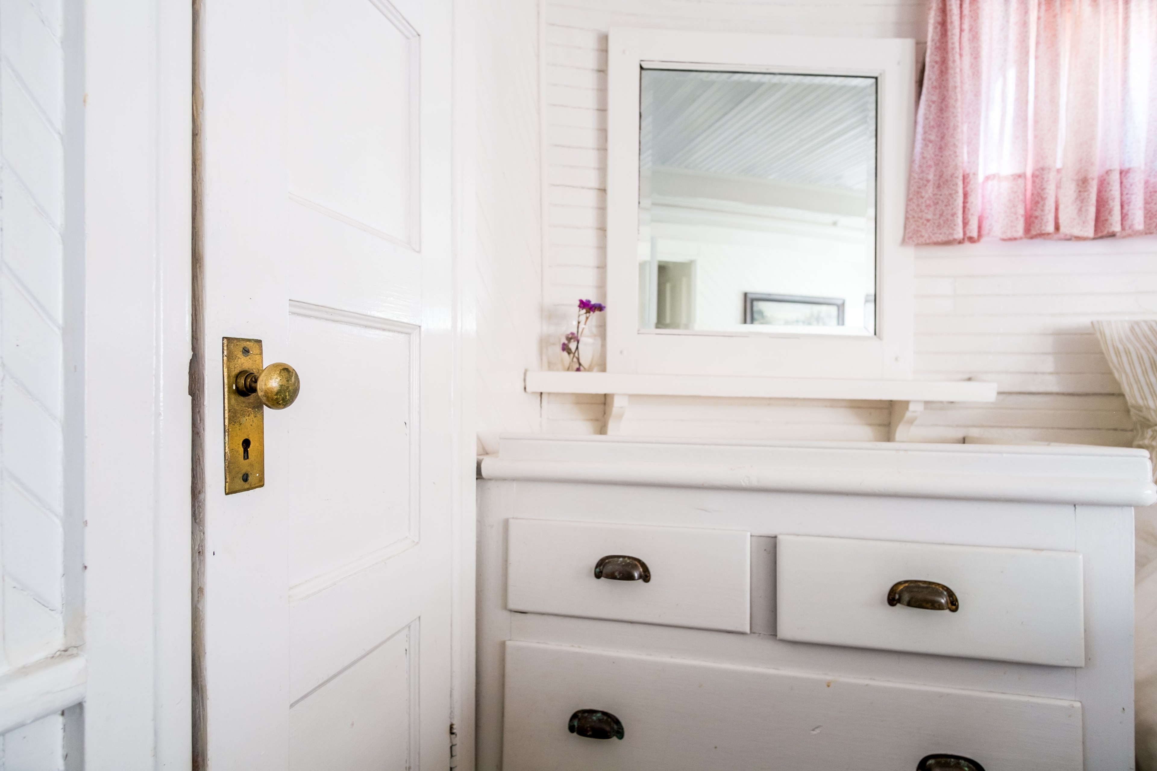 neat bathroom interior with white wooden door drawers mirror flowers and pink curtains, floating on 4k, HD Wallpaper
