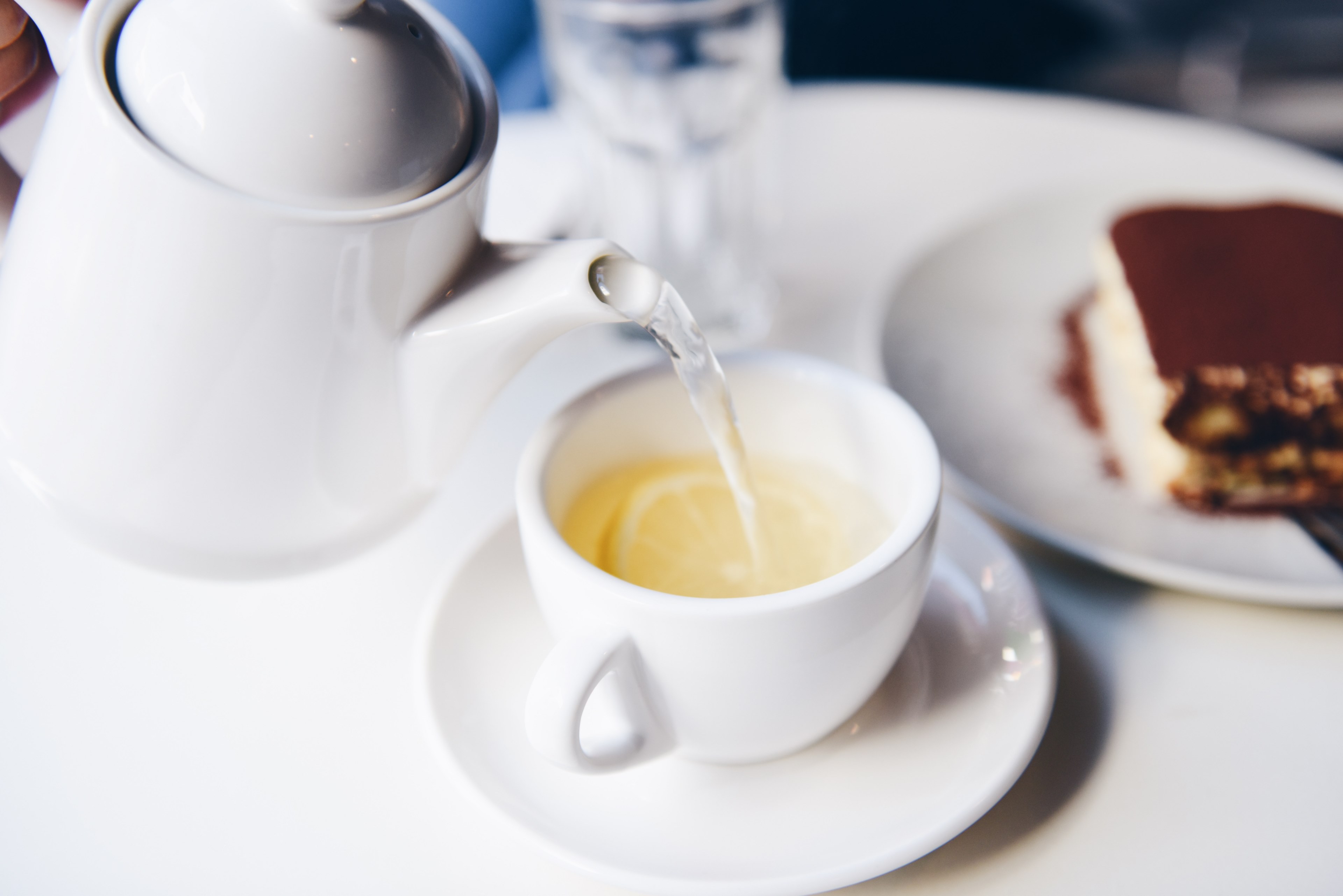 a person pouring a cup of tea into a teacup that has a lemon inside of it, teatime 4k, HD Wallpaper