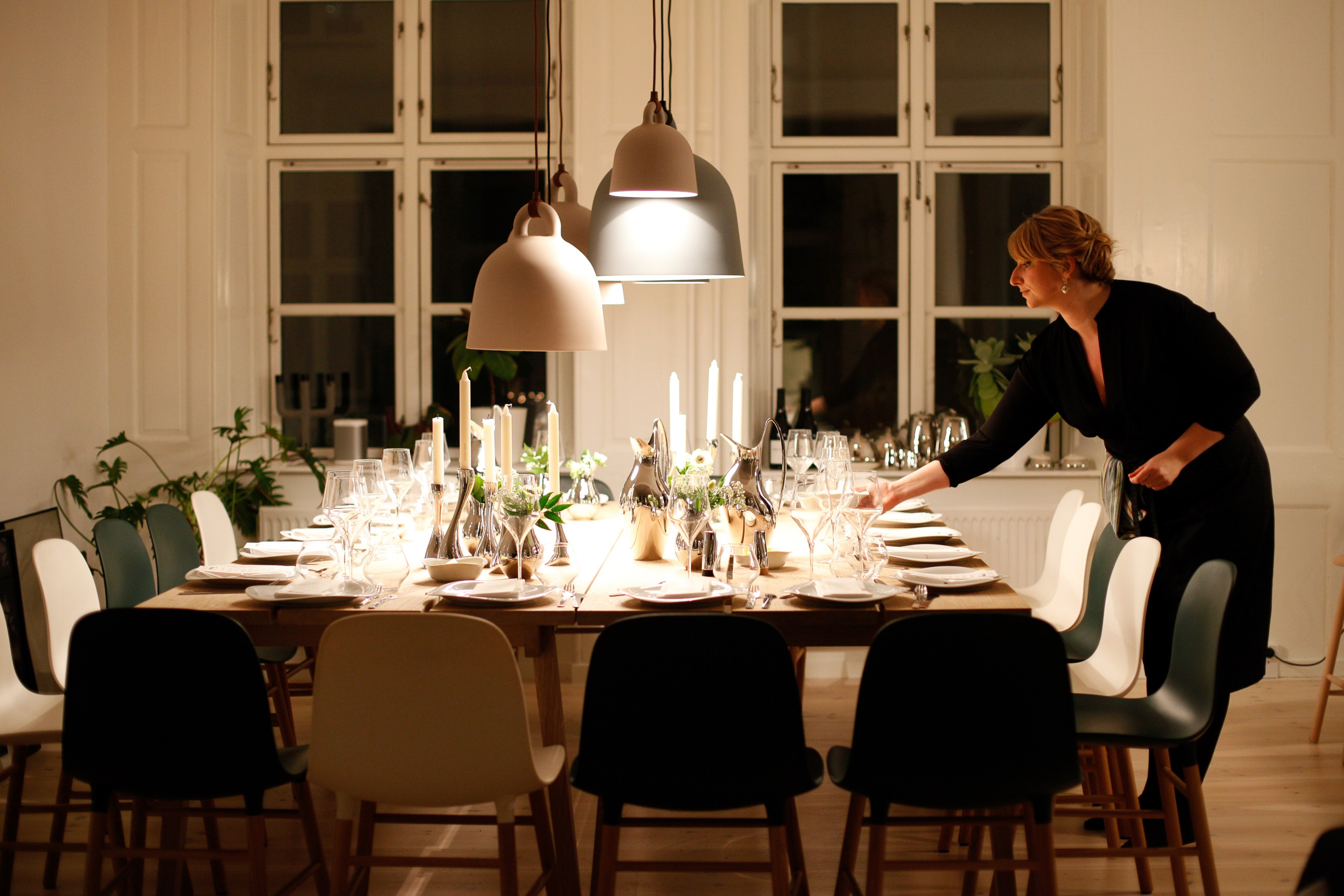a woman setting a table and lighting candles for a dinner party in her living room in copenhagen, velbekomme 4k, HD Wallpaper