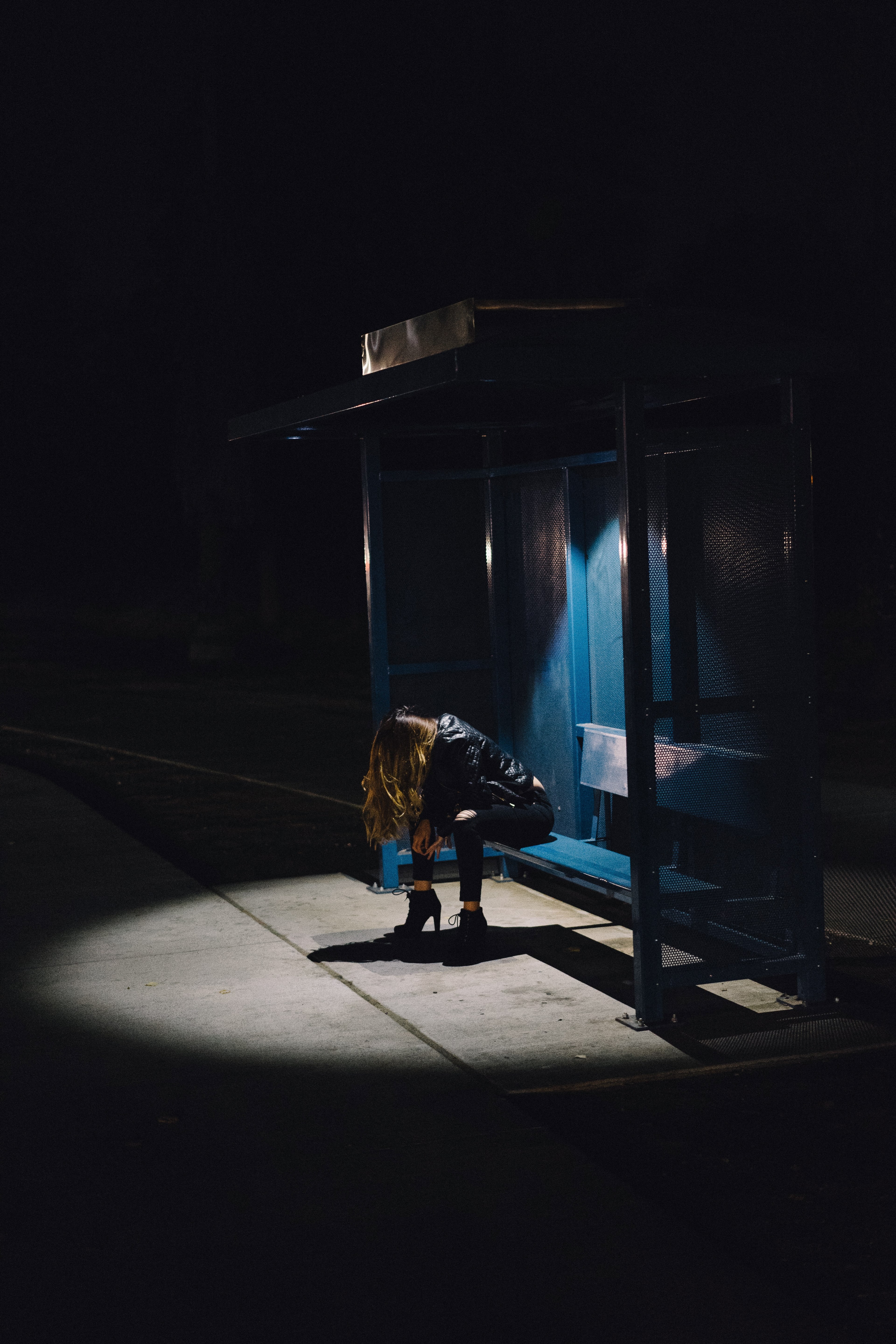 a woman with her head down being illuminated with the only lights of the bus stop, _woman lights bus stop 4k, Phone HD Wallpaper