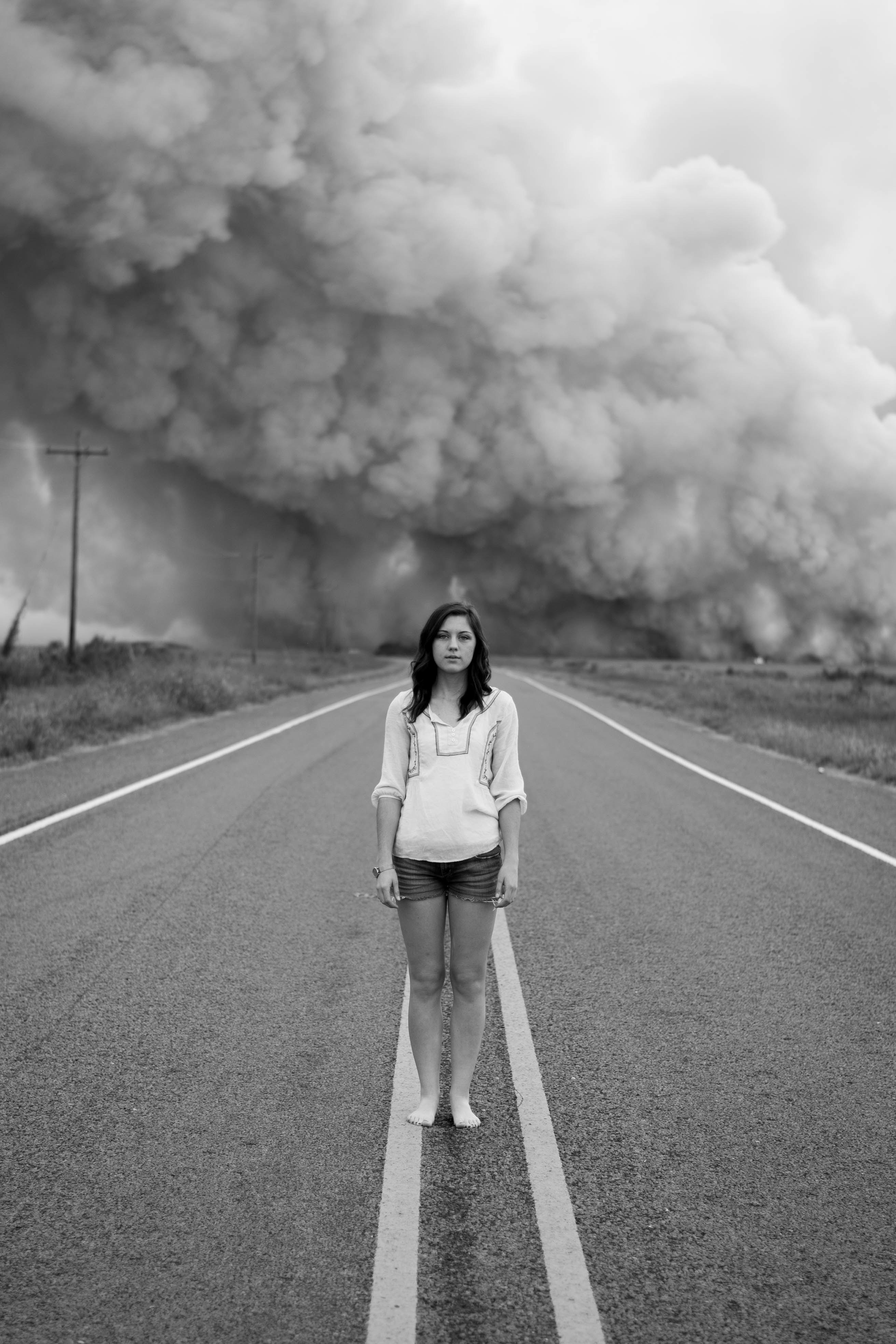 woman stands alone on an empty road as smoke billows behind her, woman and road smoke cloud 4k, Phone HD Wallpaper