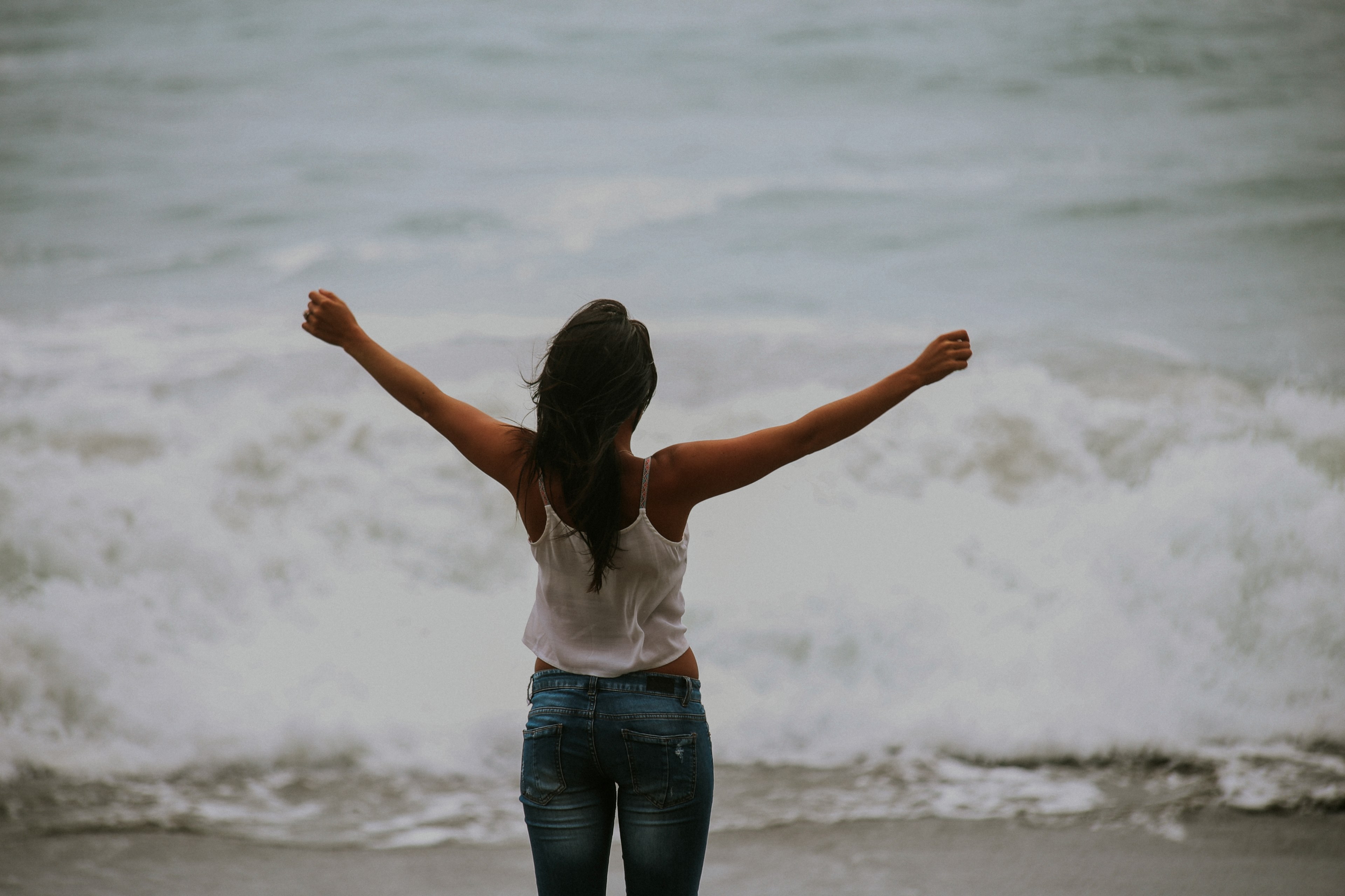 a woman wearing jeans and a white shirt staring out at the ocean with her arms up at bodega bay, bodega bay ocean 4k, HD Wallpaper