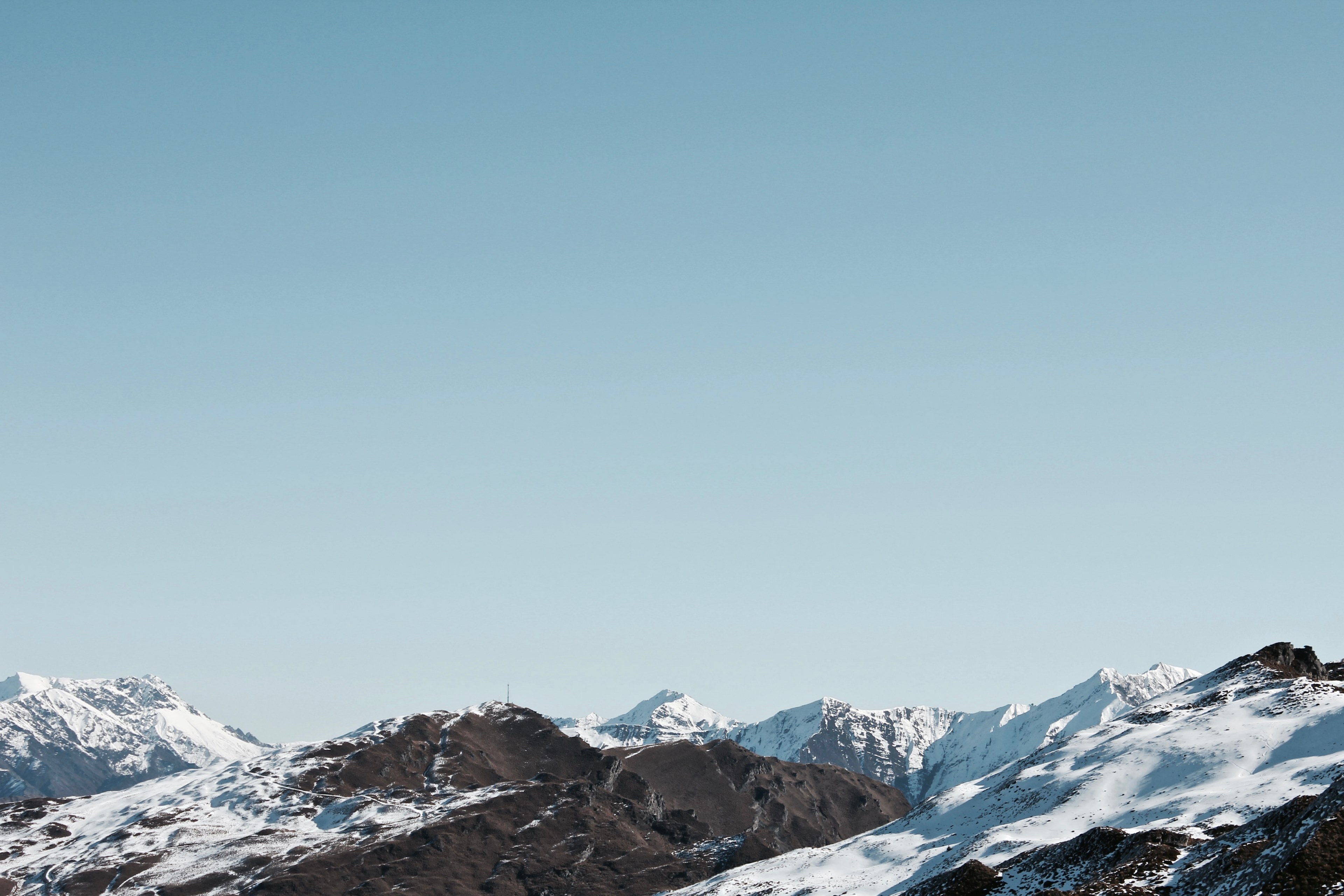 a mountain range dusted with snow under a pale blue sky, snow dusted mountain range 4k, HD Wallpaper