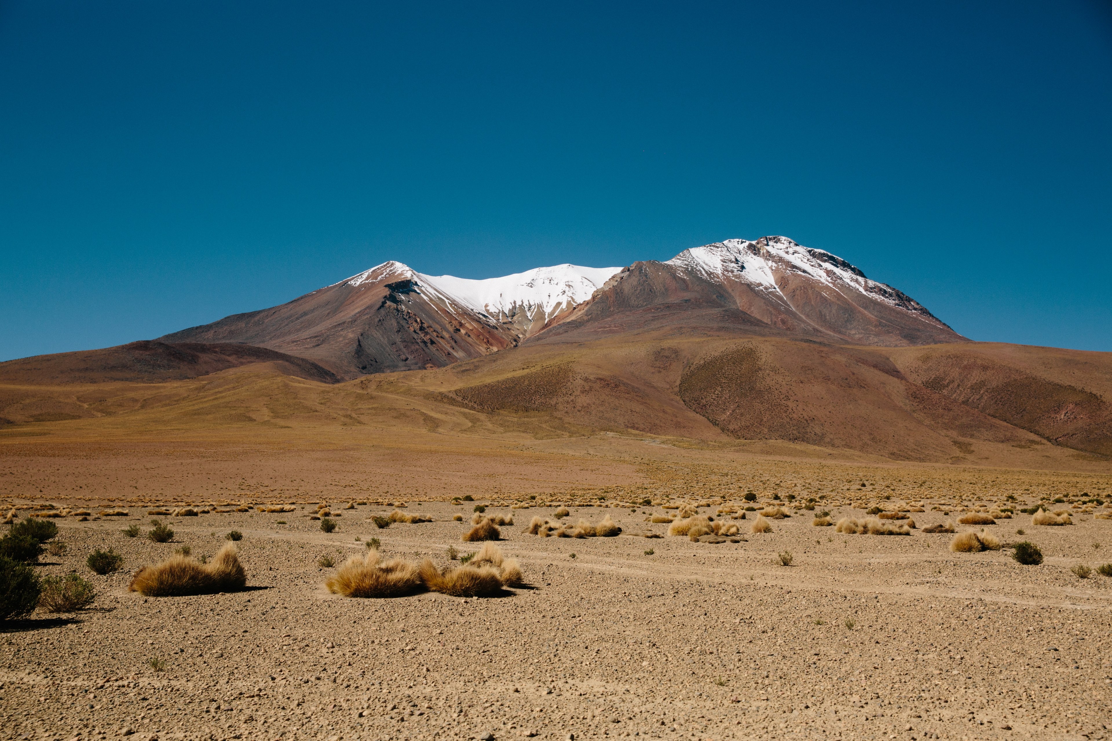 a desert with a snow capped mountain far off in the distance, a snowy mountain in the desert 4k, HD Wallpaper