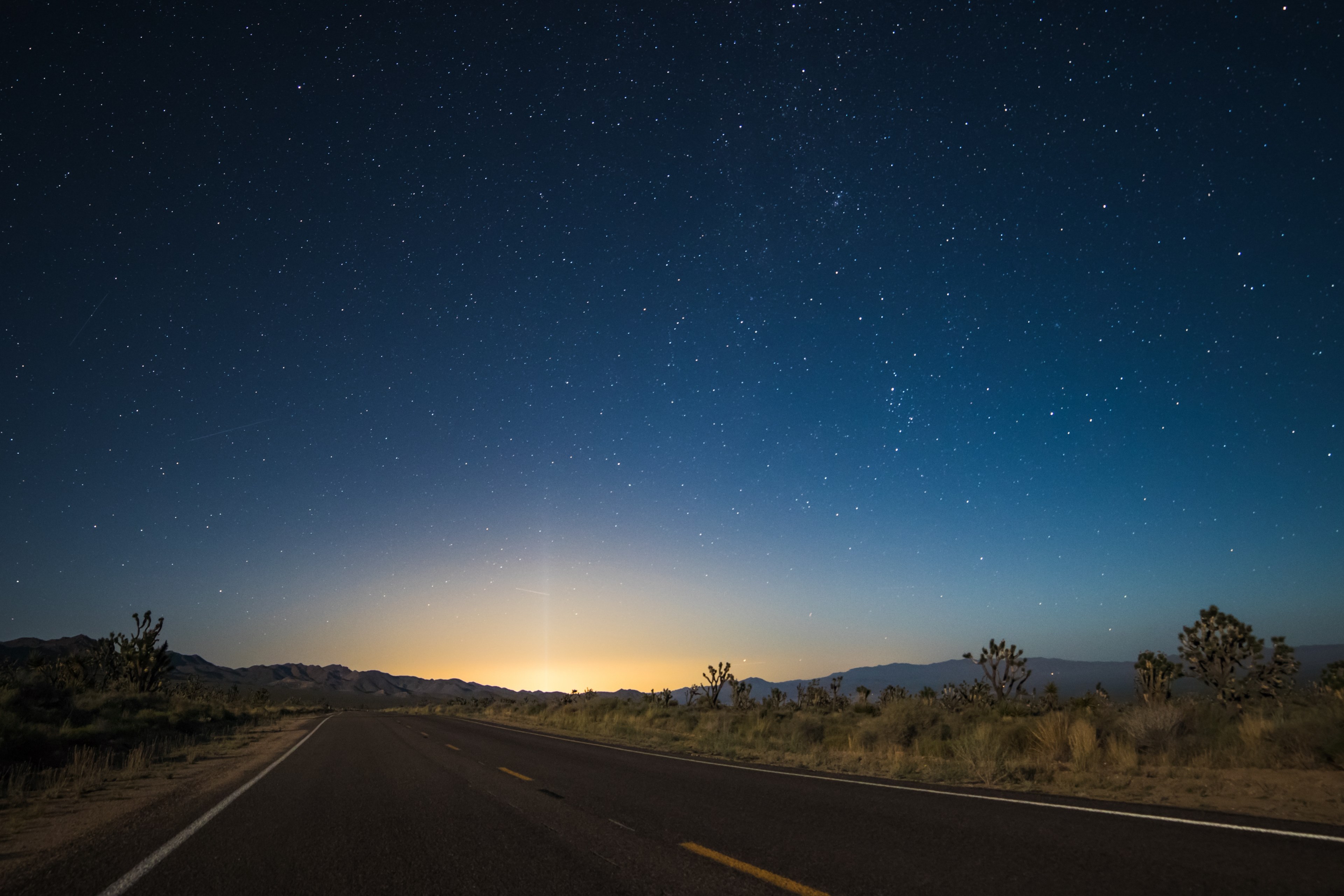 the pavement in the center of desert area leads to glowing sunrise illuminating night sky, starry sky transition at nipton 4k, HD Wallpaper